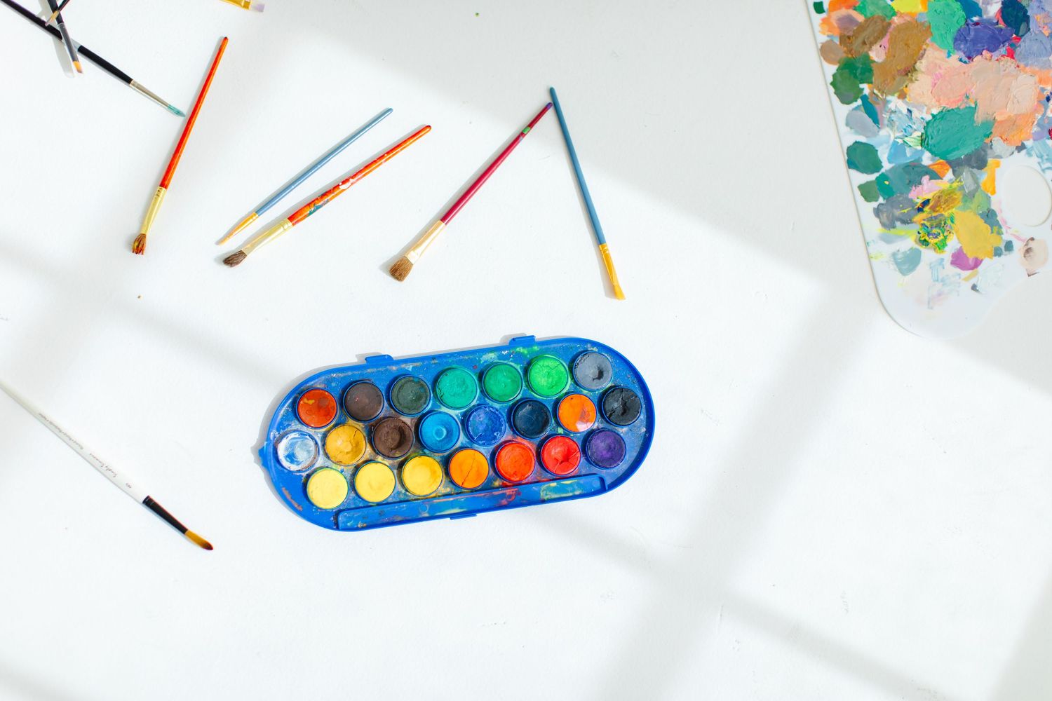 Watercolor paint set with colorful pigments and brushes on white surface at White Space Studios in Provo, Utah in Utah County.