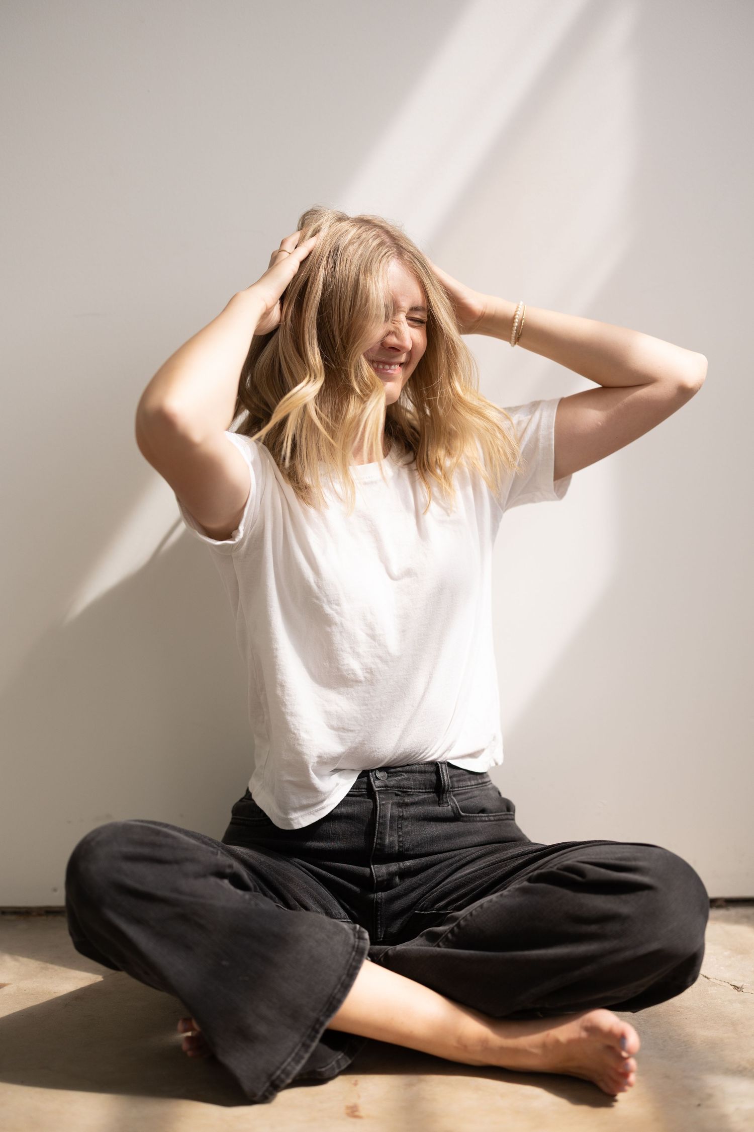 A series of dynamic poses showing a person in a white shirt and black pants moving expressively against a light wall.