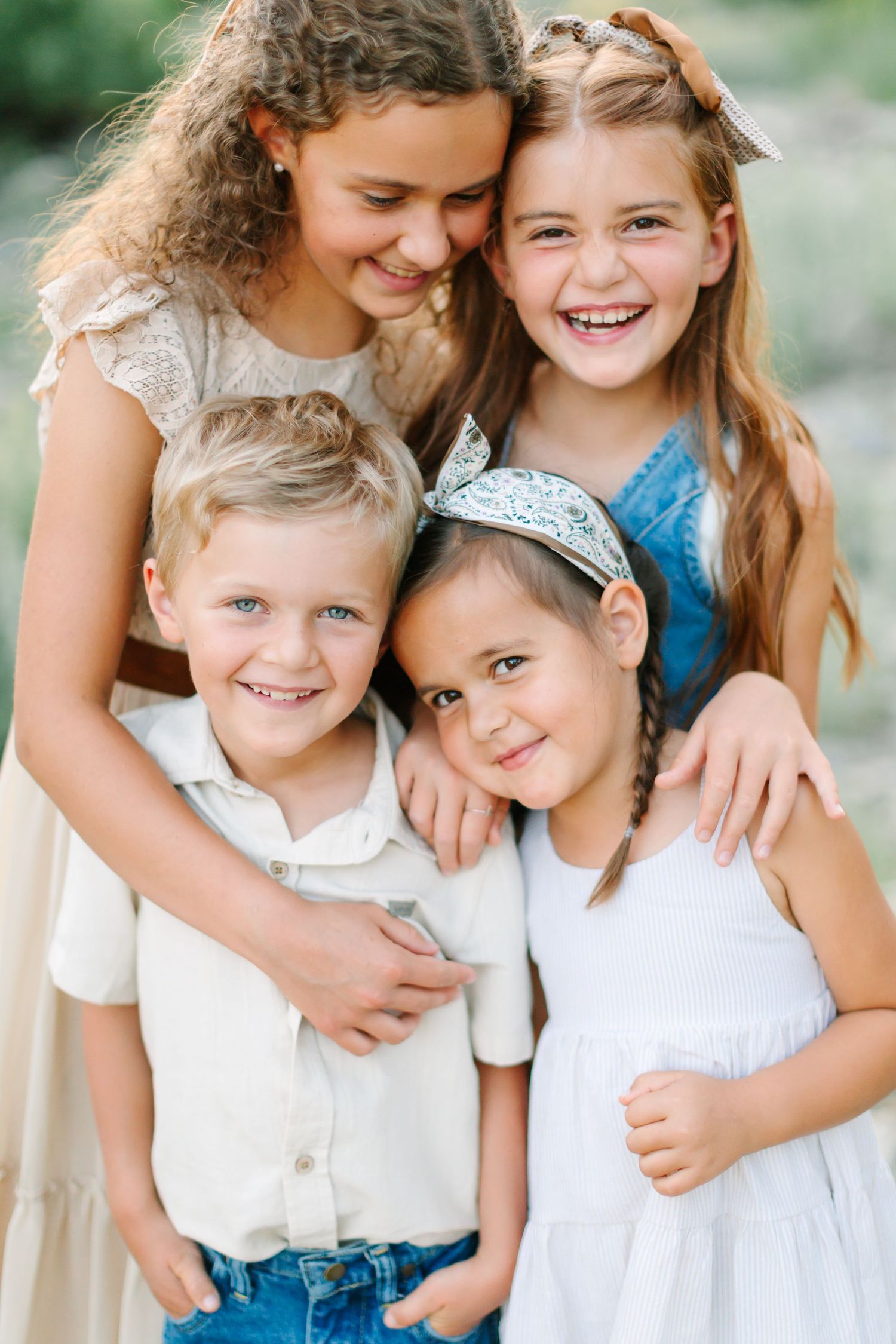A series of candid family photos showing joyful embraces and laughter between siblings in white and blue casual attire.