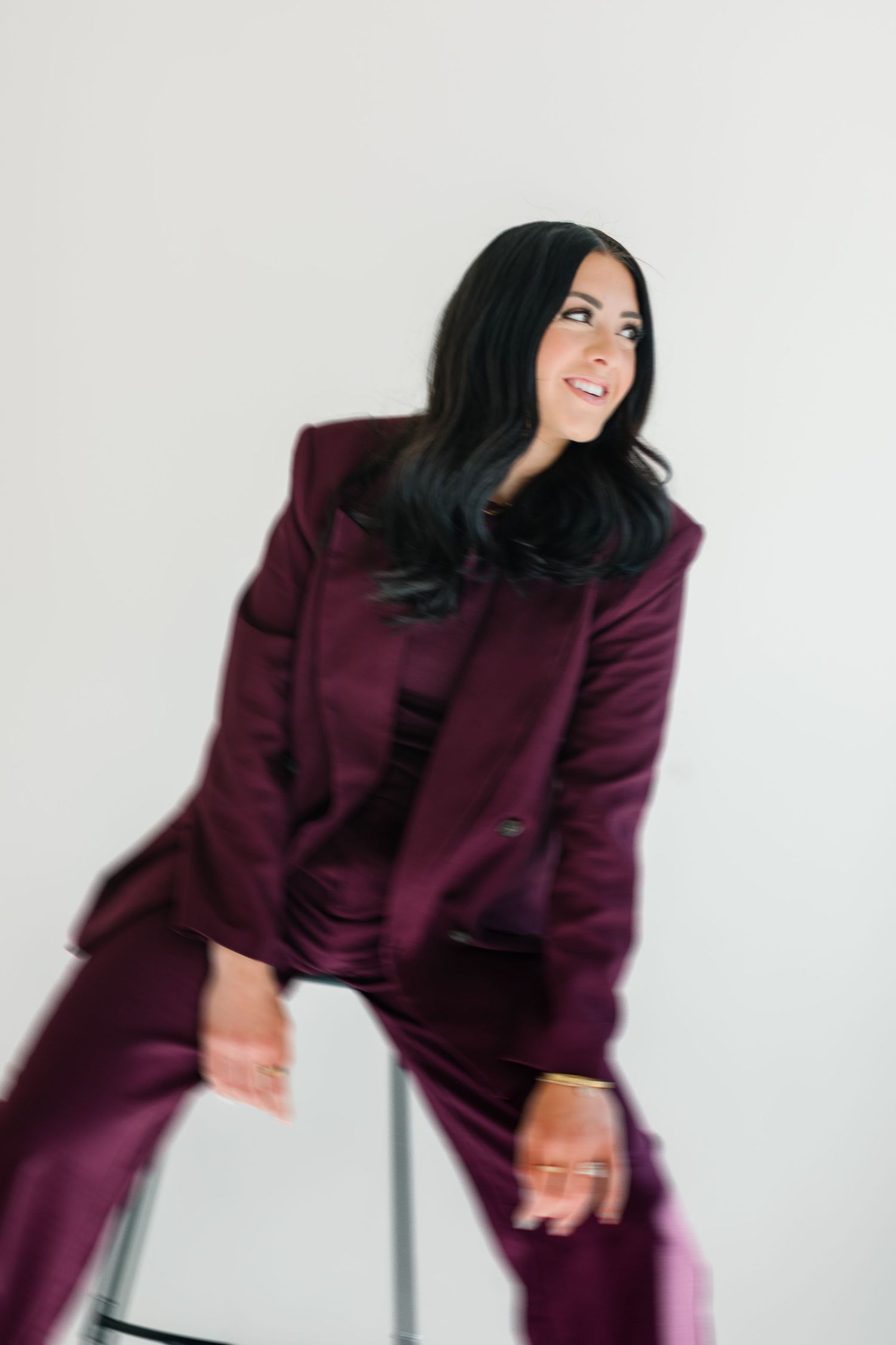 Dynamic fashion poses in a burgundy suit against a minimalist white studio background at White Space Studios in Provo, Utah in Utah County..