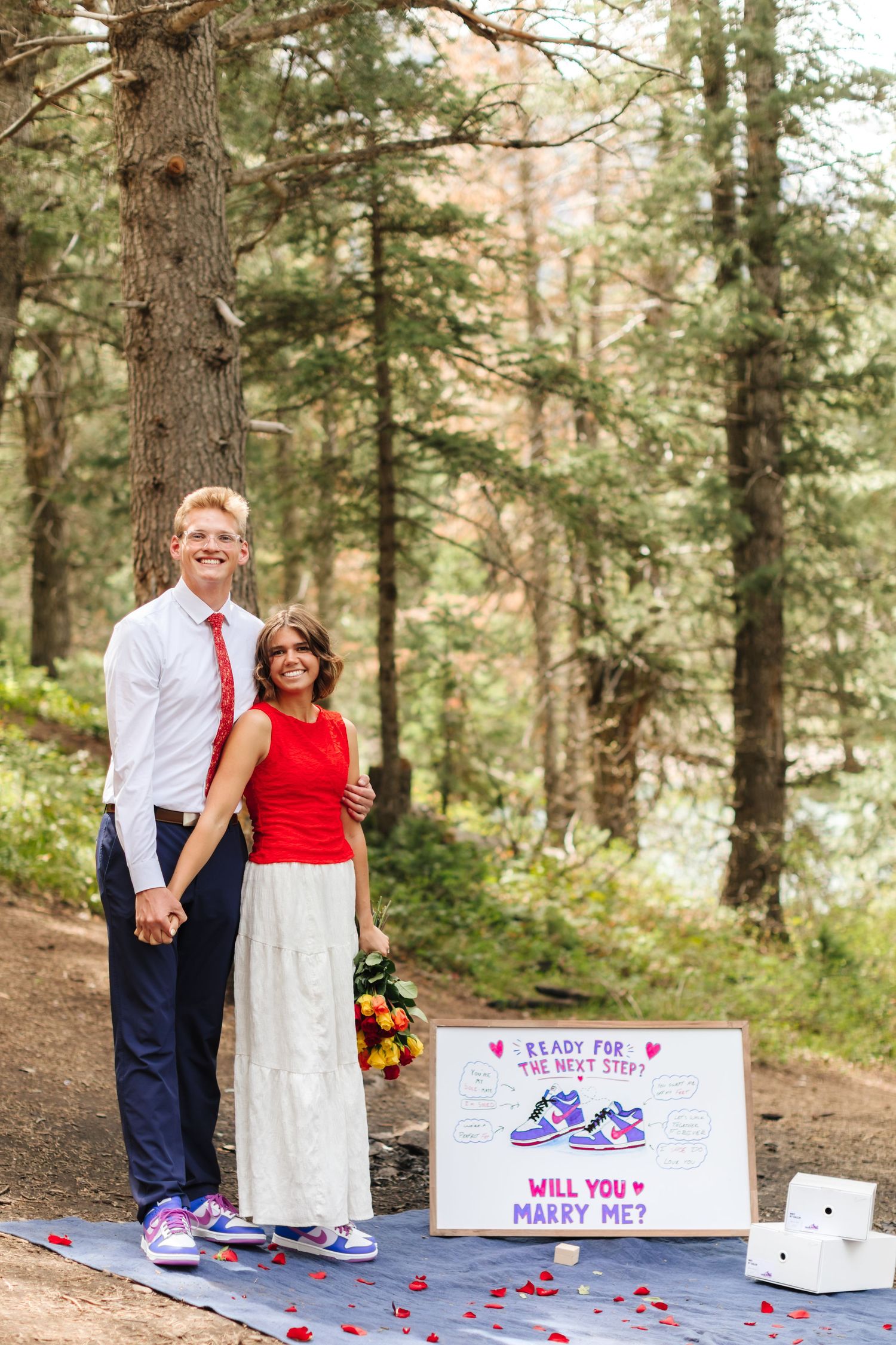 Couple poses in forest beside a romantic 