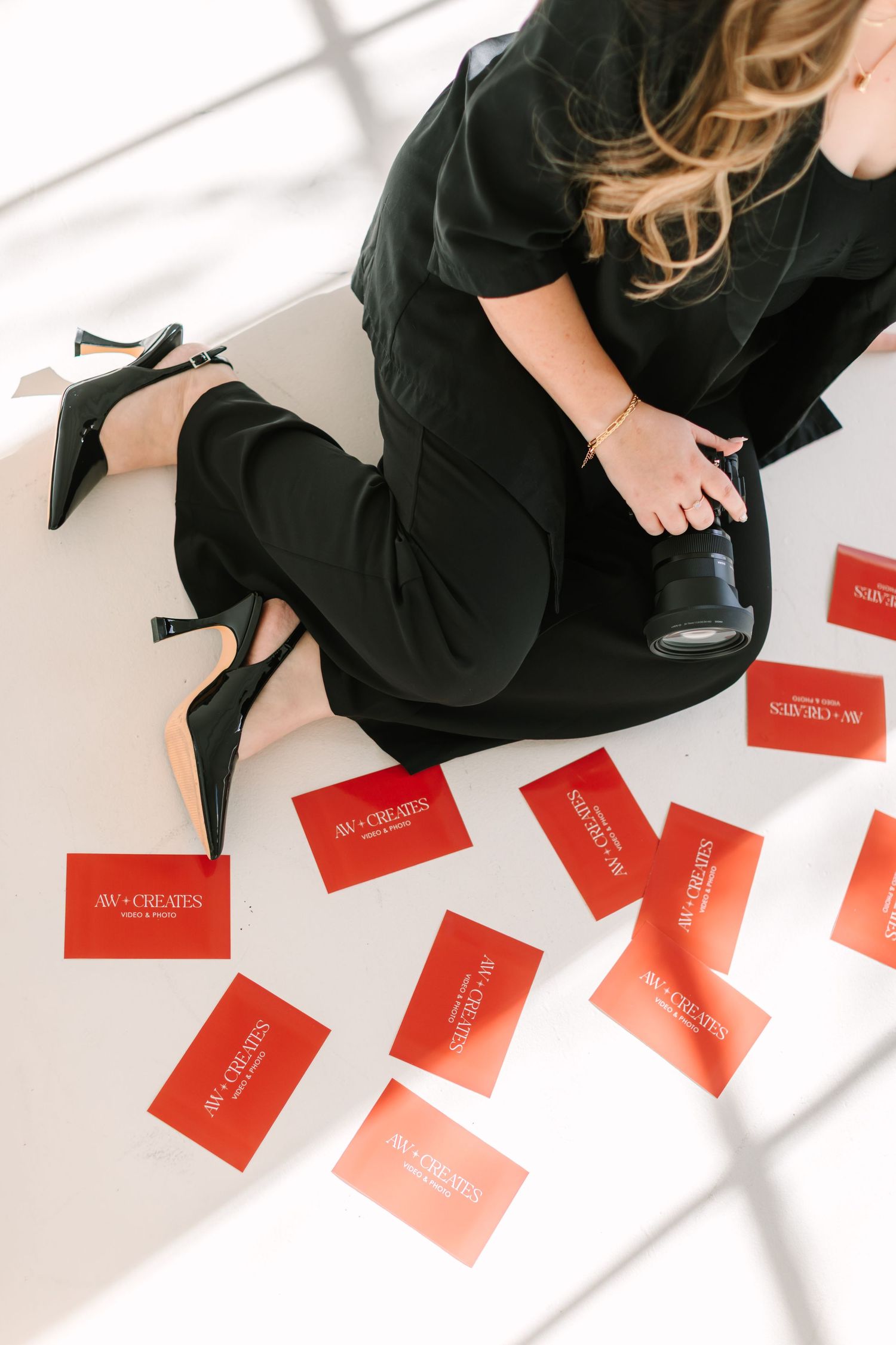 Multiple red envelopes or cards scattered on white surface with person in black dress visible in frame.