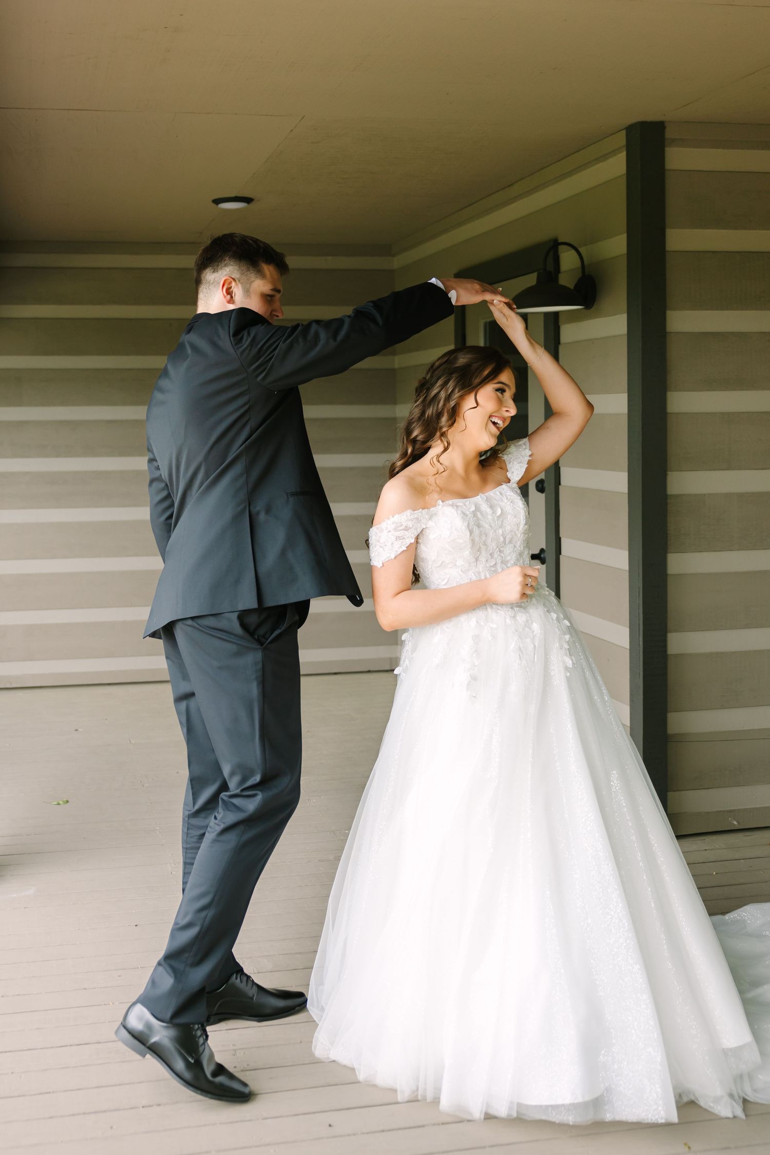 A couple in formal wedding attire dances together in a sequence of graceful twirling movements.