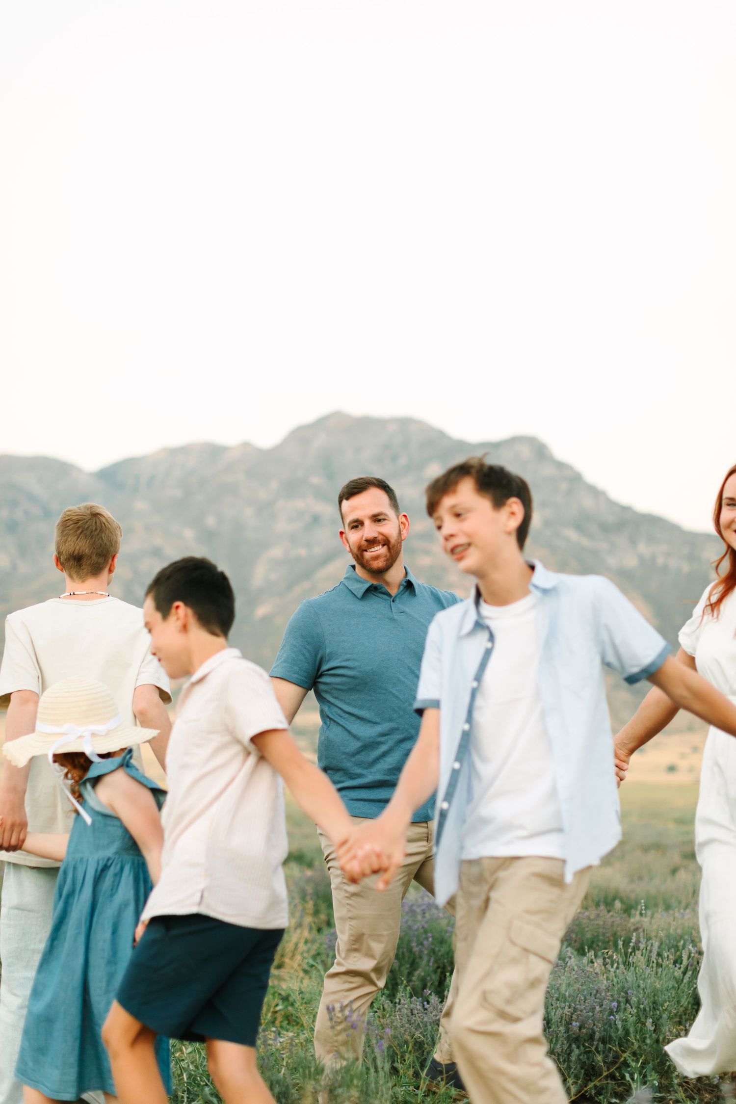 A group of people dancing and celebrating outdoors with mountains visible in the background.