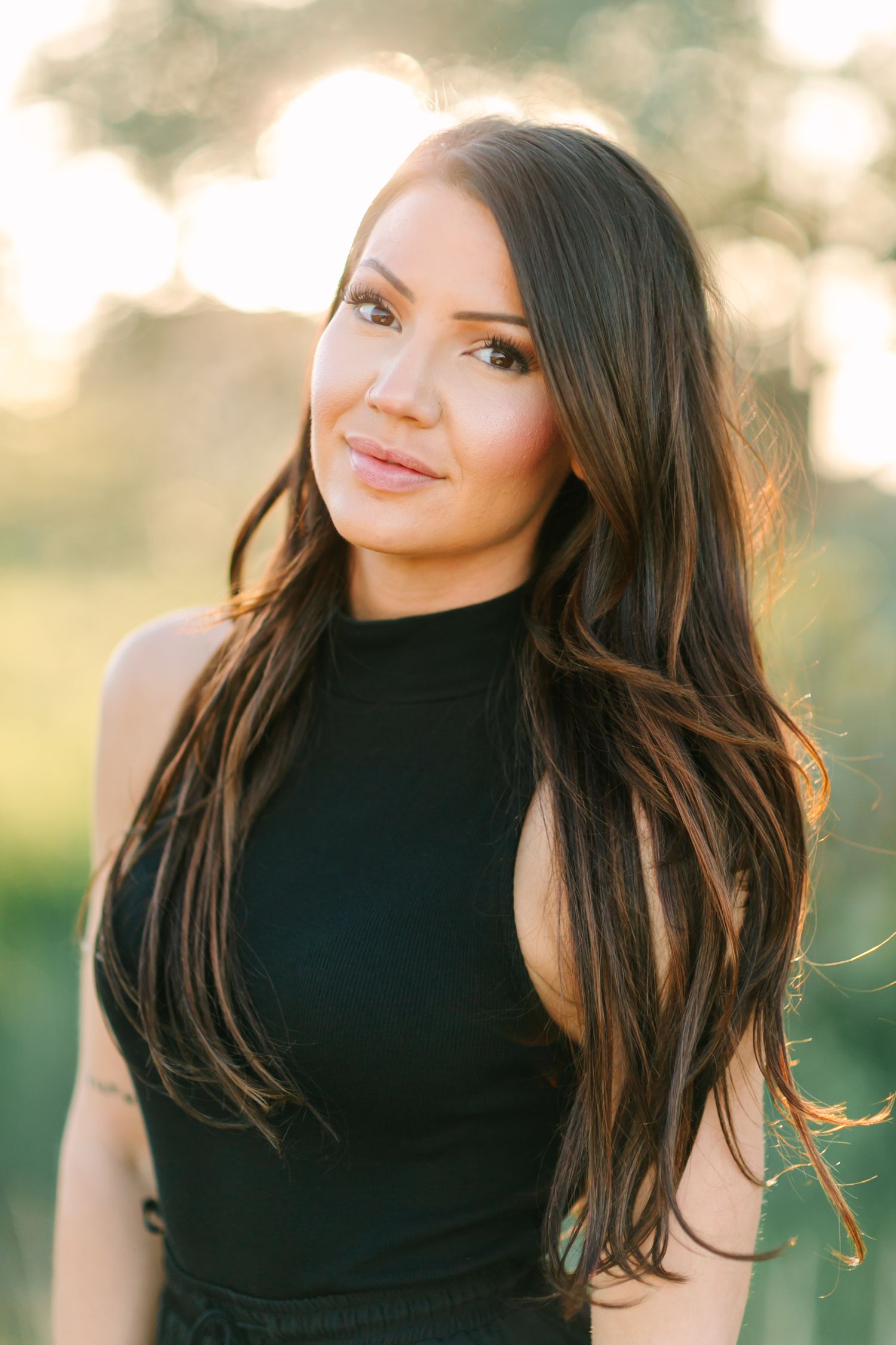 Portrait series showing long dark hair flowing in warm sunlight against a natural blurred background.