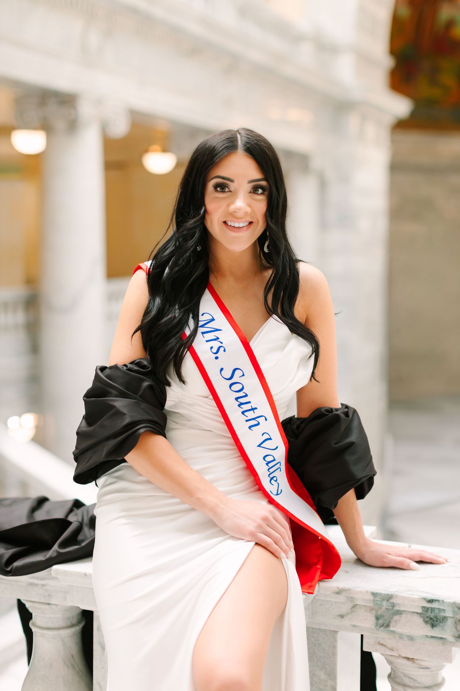 A person in a white dress and black jacket poses gracefully in a series of connected photos in a bright indoor setting.