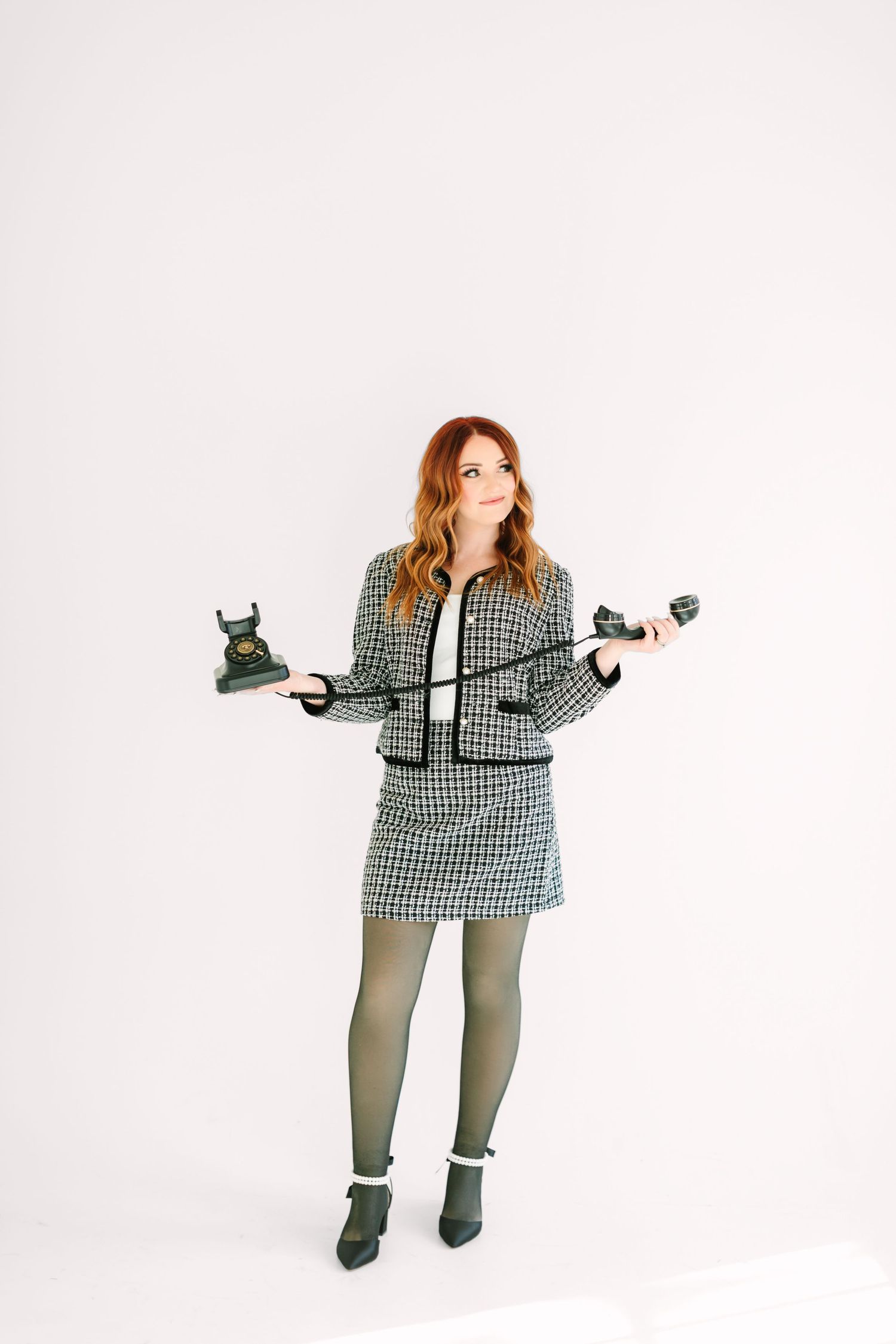 Woman in black and white checkered top and gray pants strikes dynamic poses against white background.