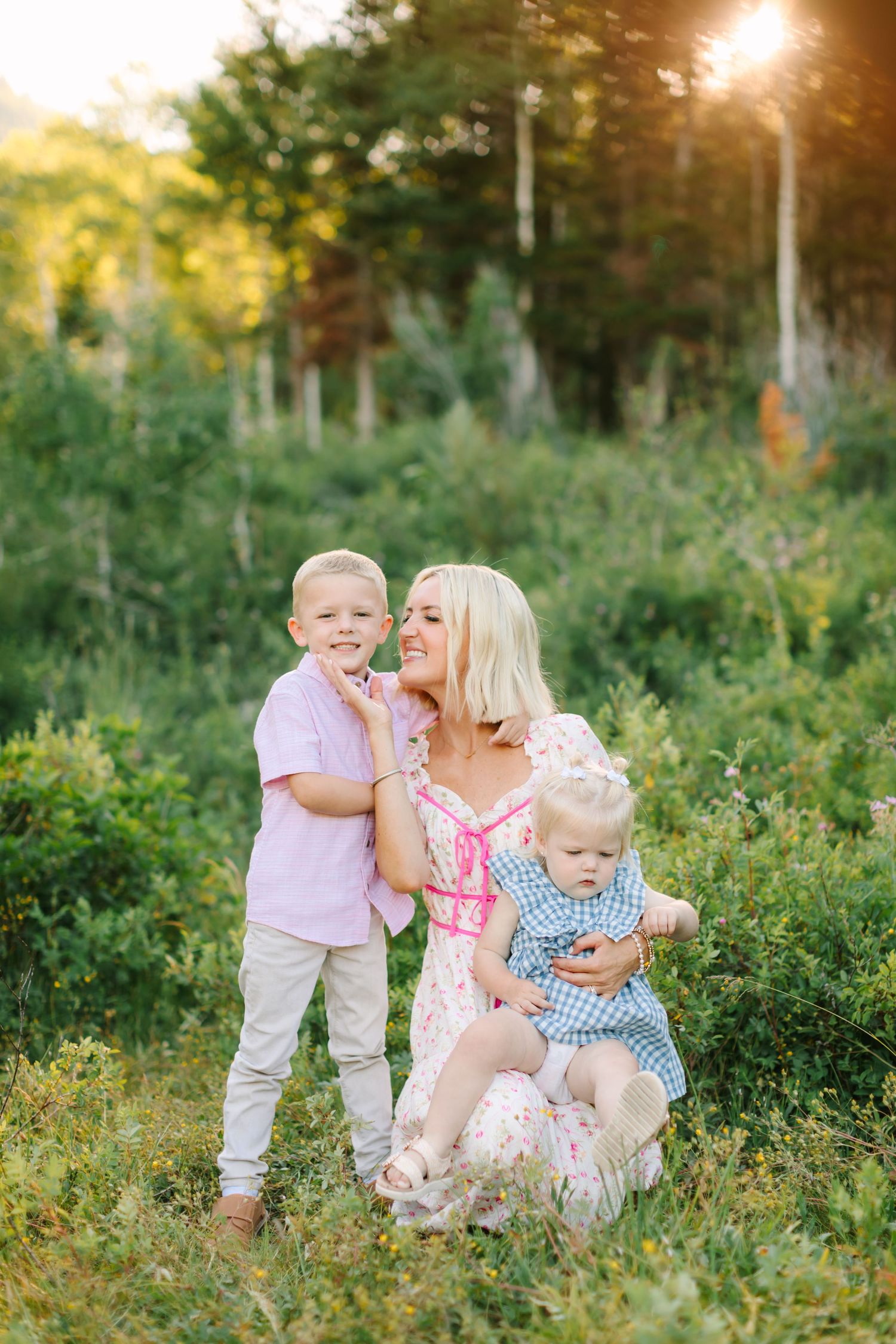 Family of four at their family photoshoot in American Fork, Utah amongst a green meadow in summer.