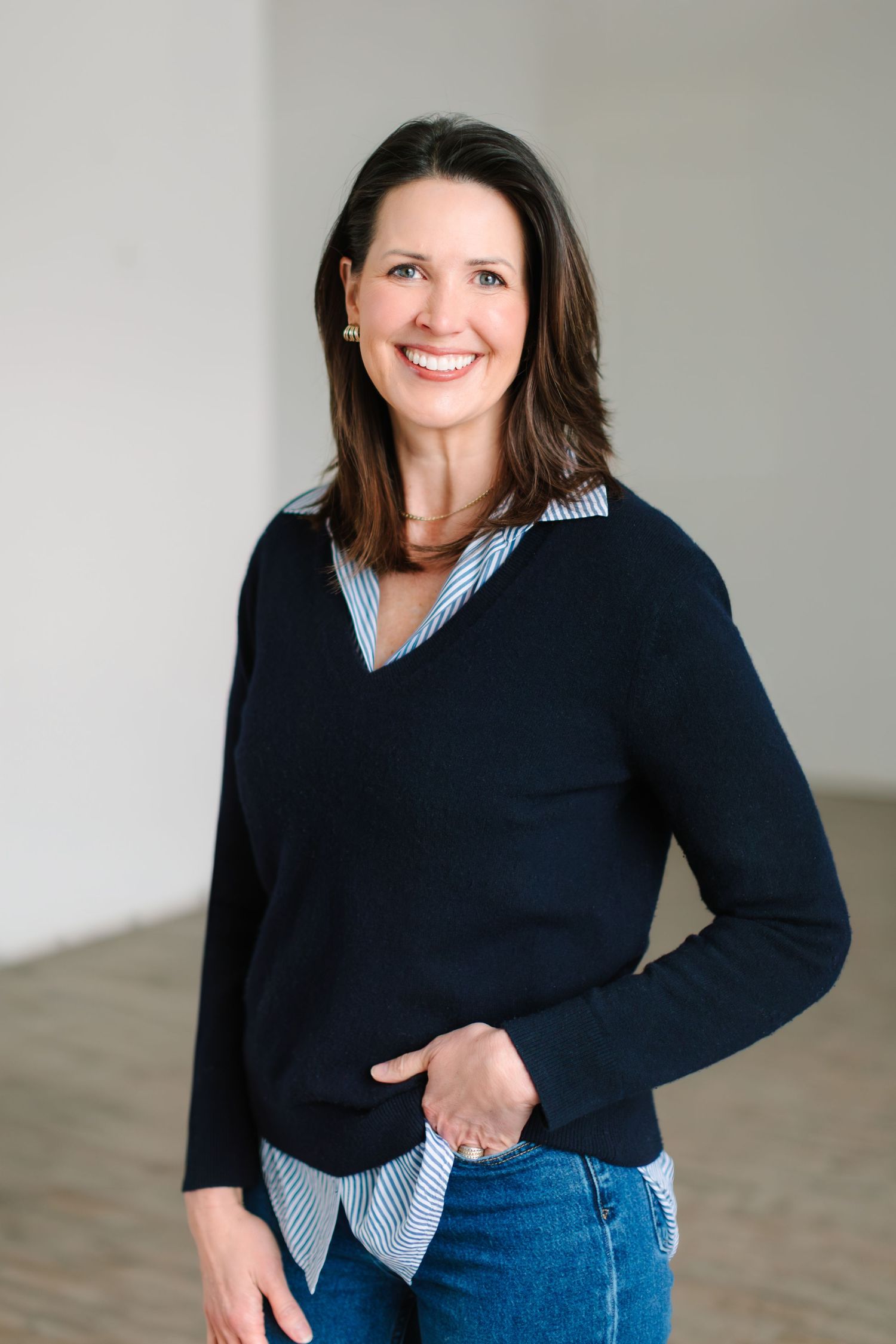 A casual lifestyle portrait session featuring a navy sweater and striped shirt combination against a white backdrop.