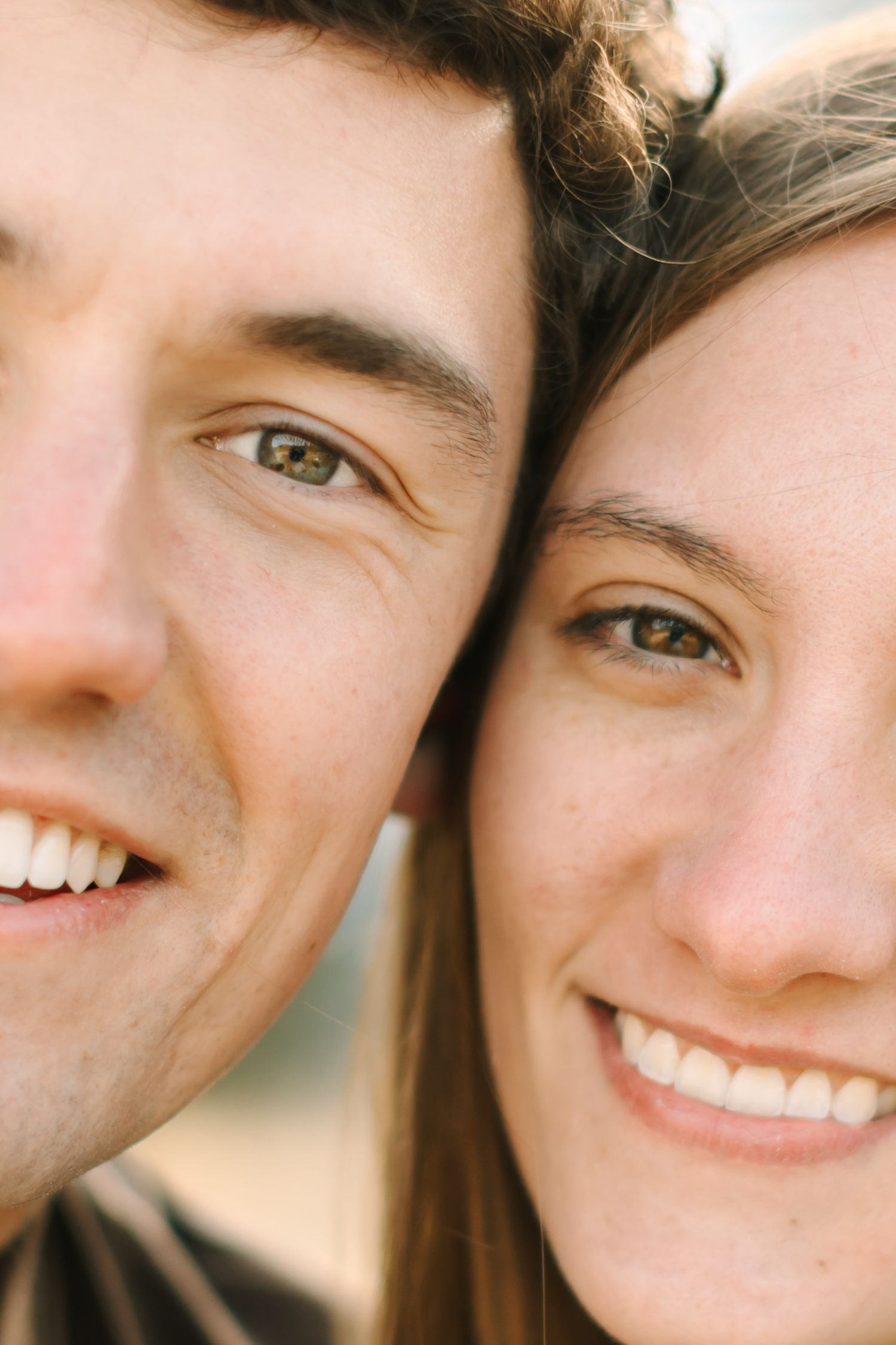 Close-up photo showing bright smiles and joyful expressions in a casual portrait setting.