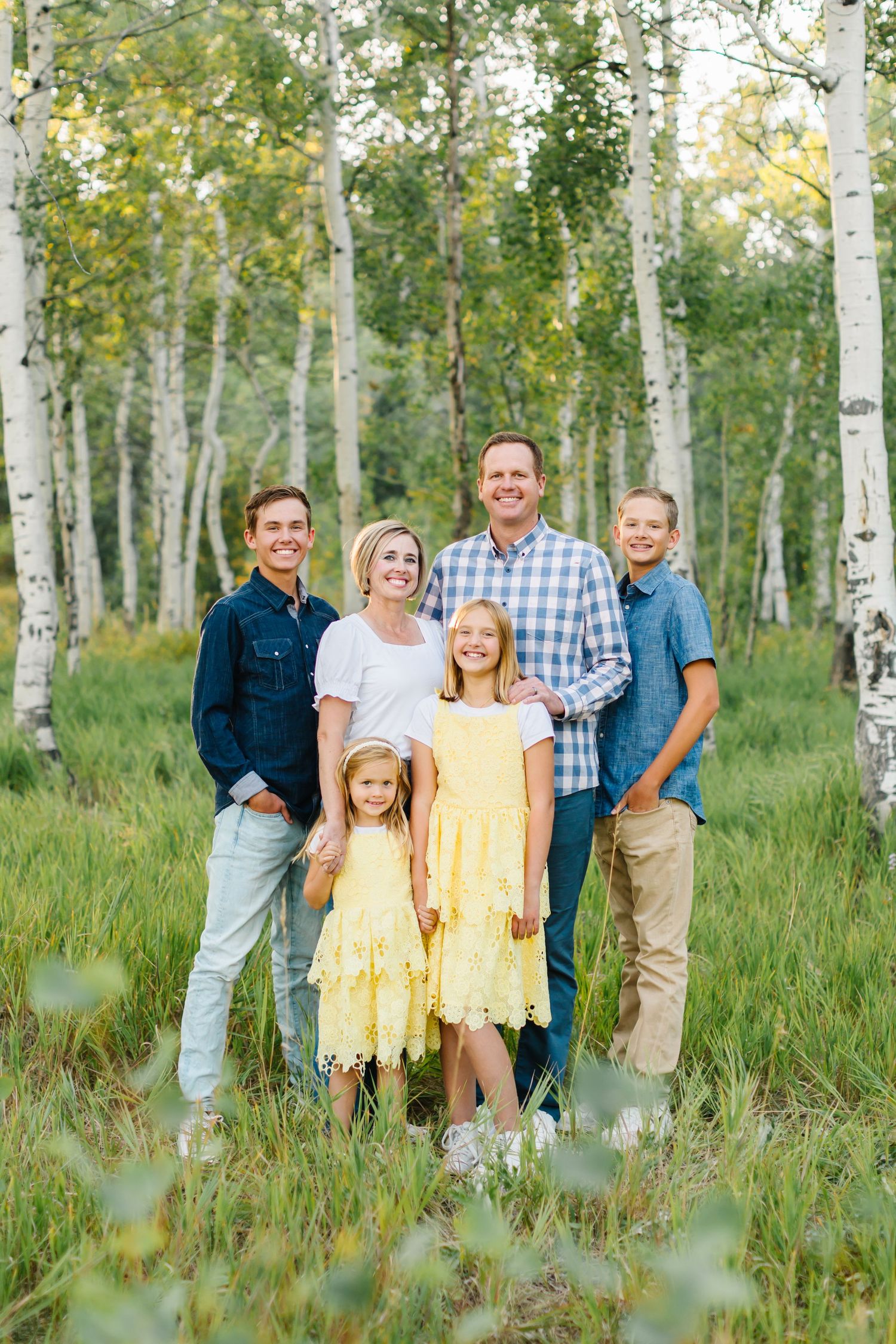 Family surrounded by green aspen trees for their family photoshoot in Midway, Utah up Provo Canyon in Utah County.