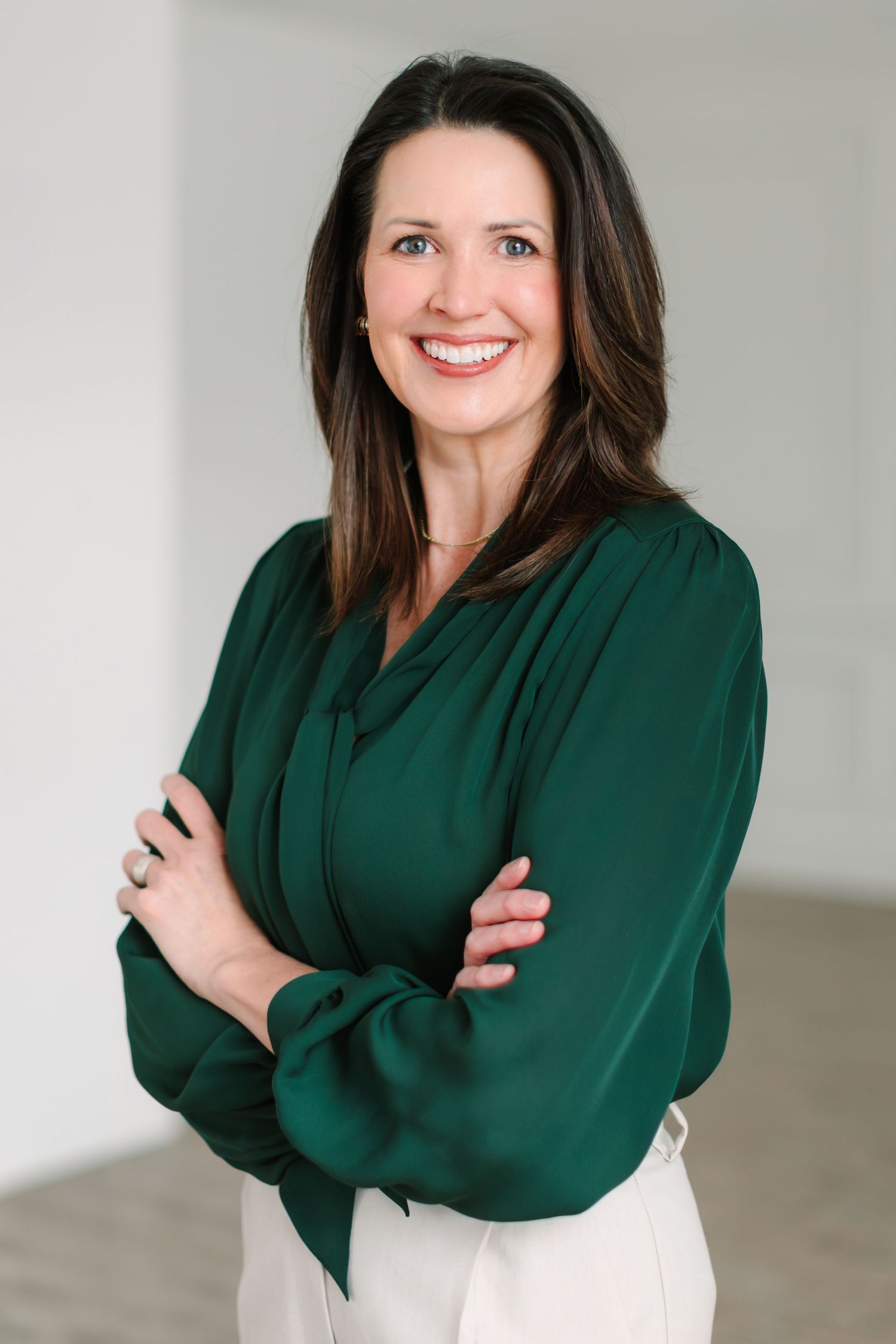 Professional portrait series showing a woman in emerald green blouse posing against white background with warm smile.
