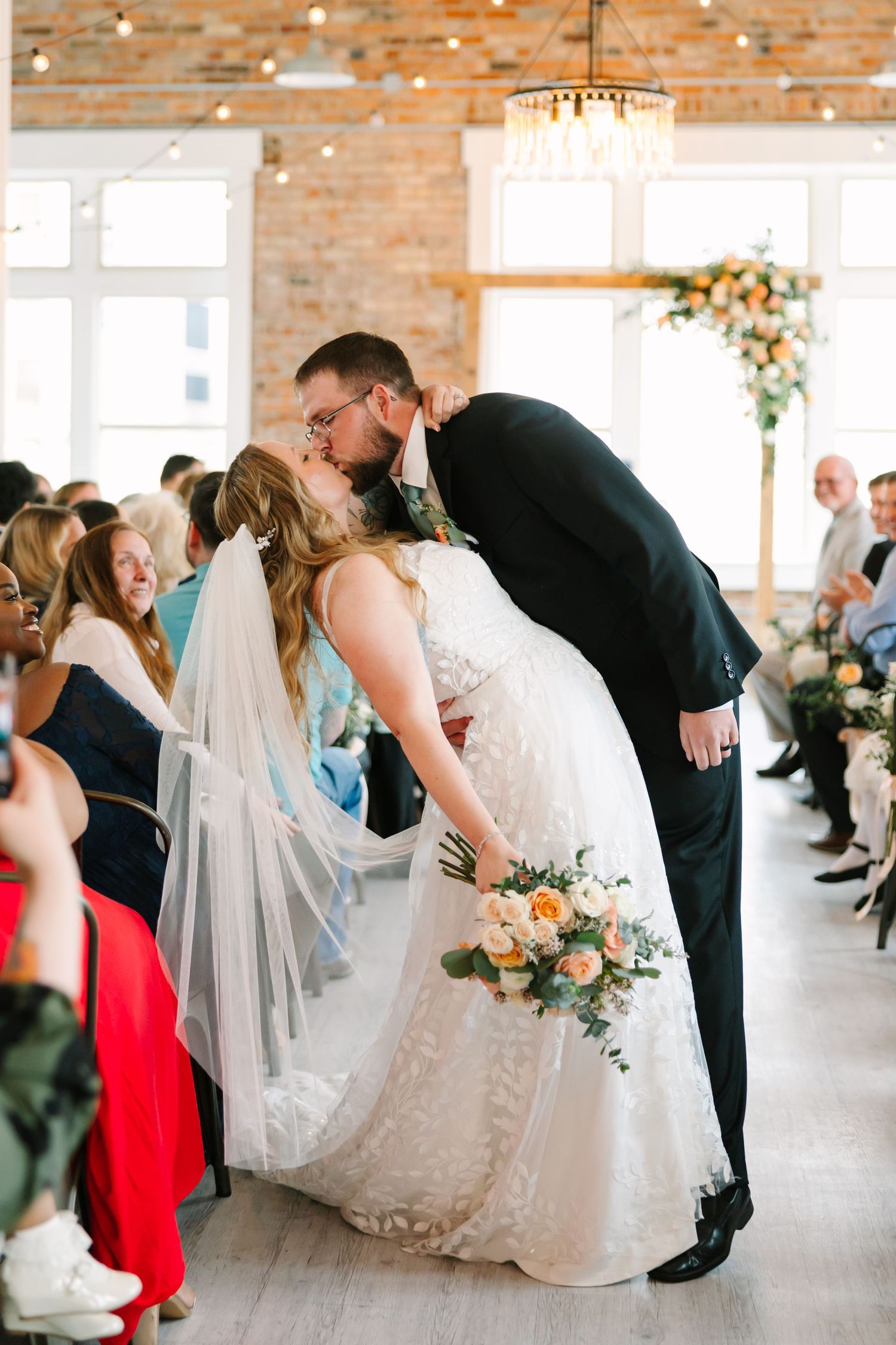 A romantic wedding photo collage showing three couples dipping their partners during their first dance in a rustic brick venue.