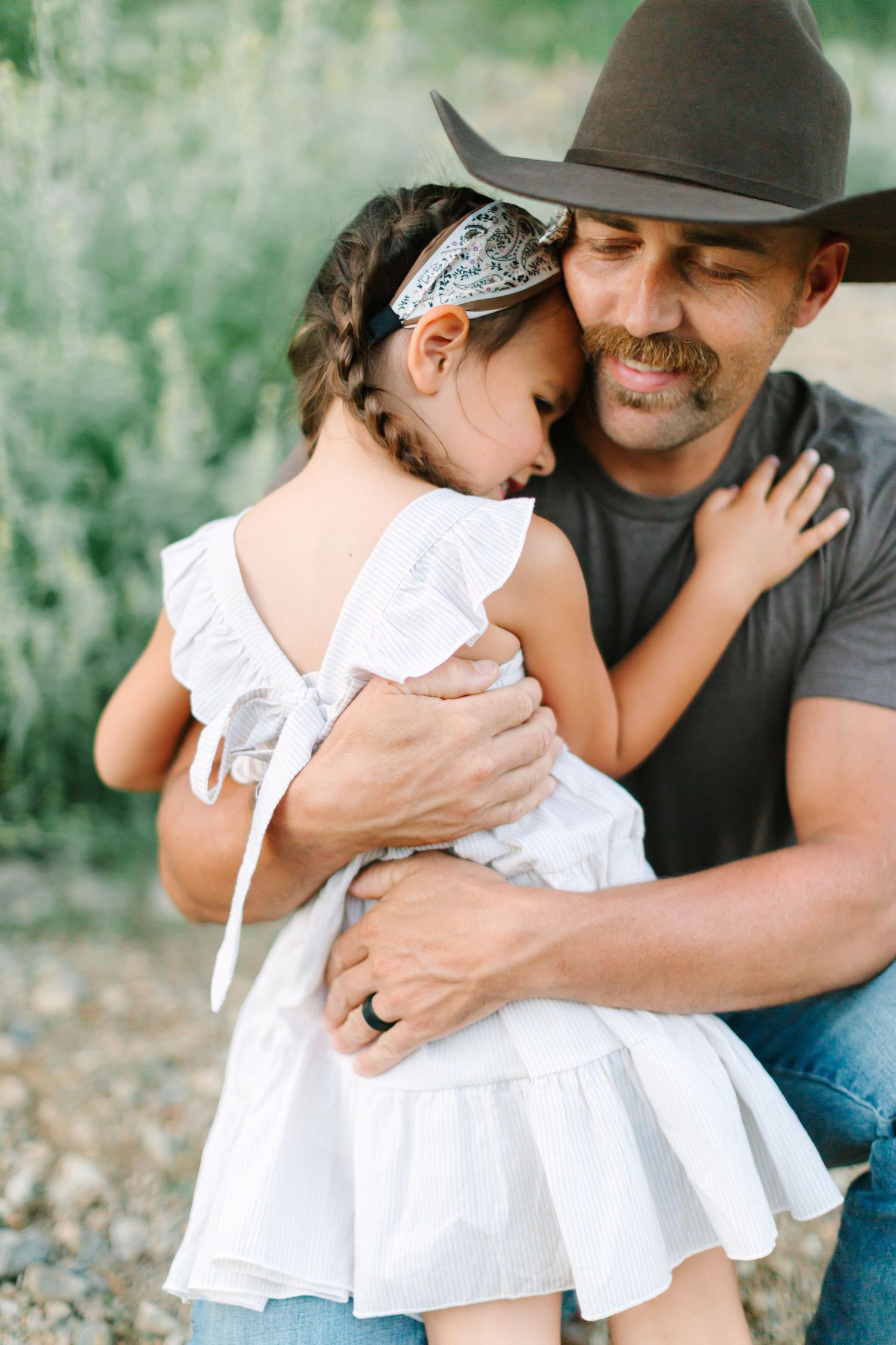A tender moment between parent and child in white dress captured in multiple frames against a green outdoor background.