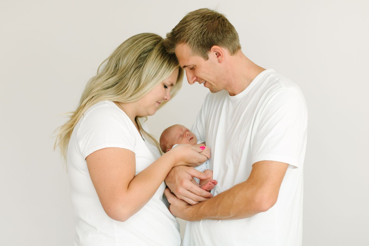 A tender series of black and white photos showing a couple in white shirts sharing intimate moments together.