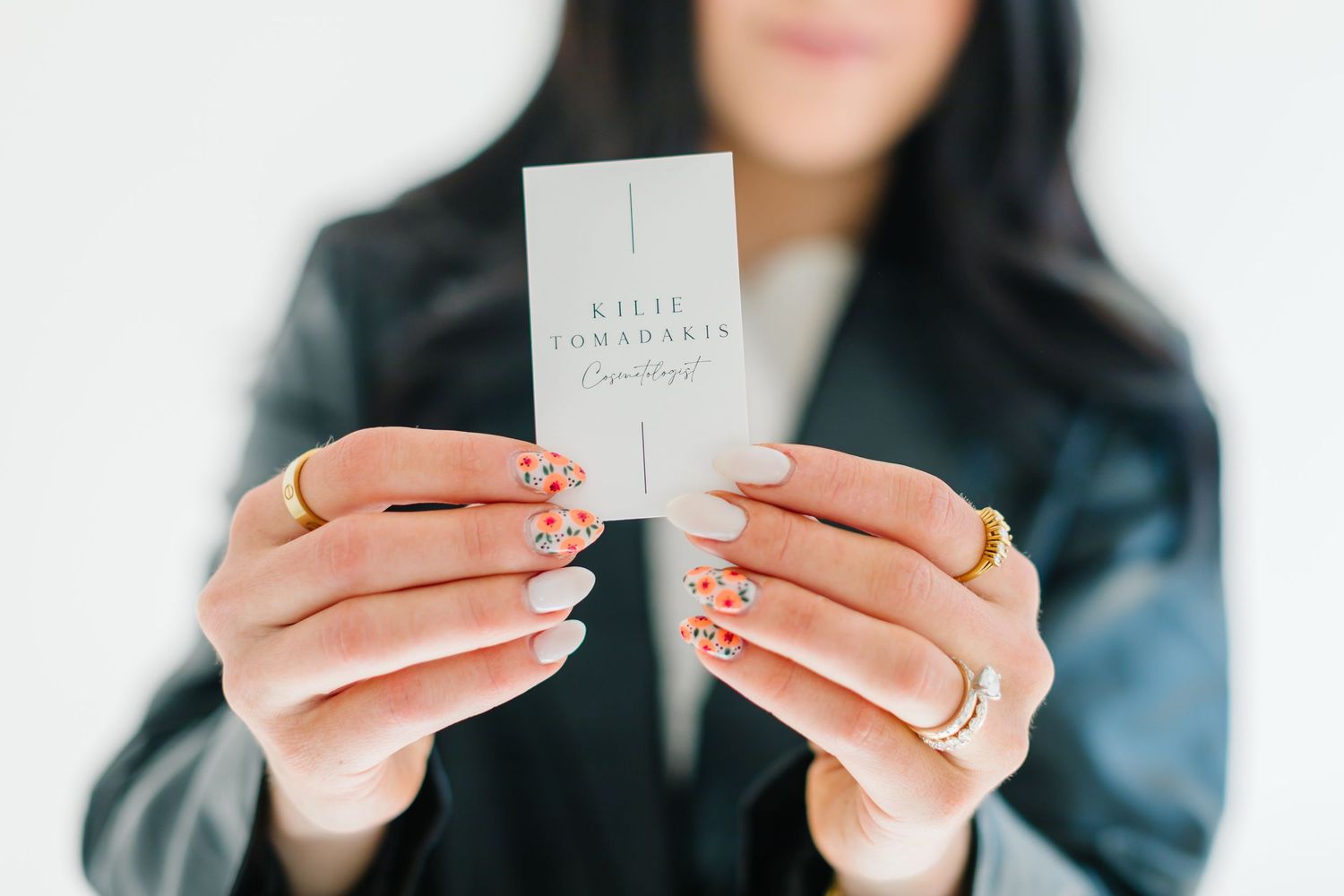 Hands holding small white business cards against light background at White Space Studios in Provo, Utah in Utah County..