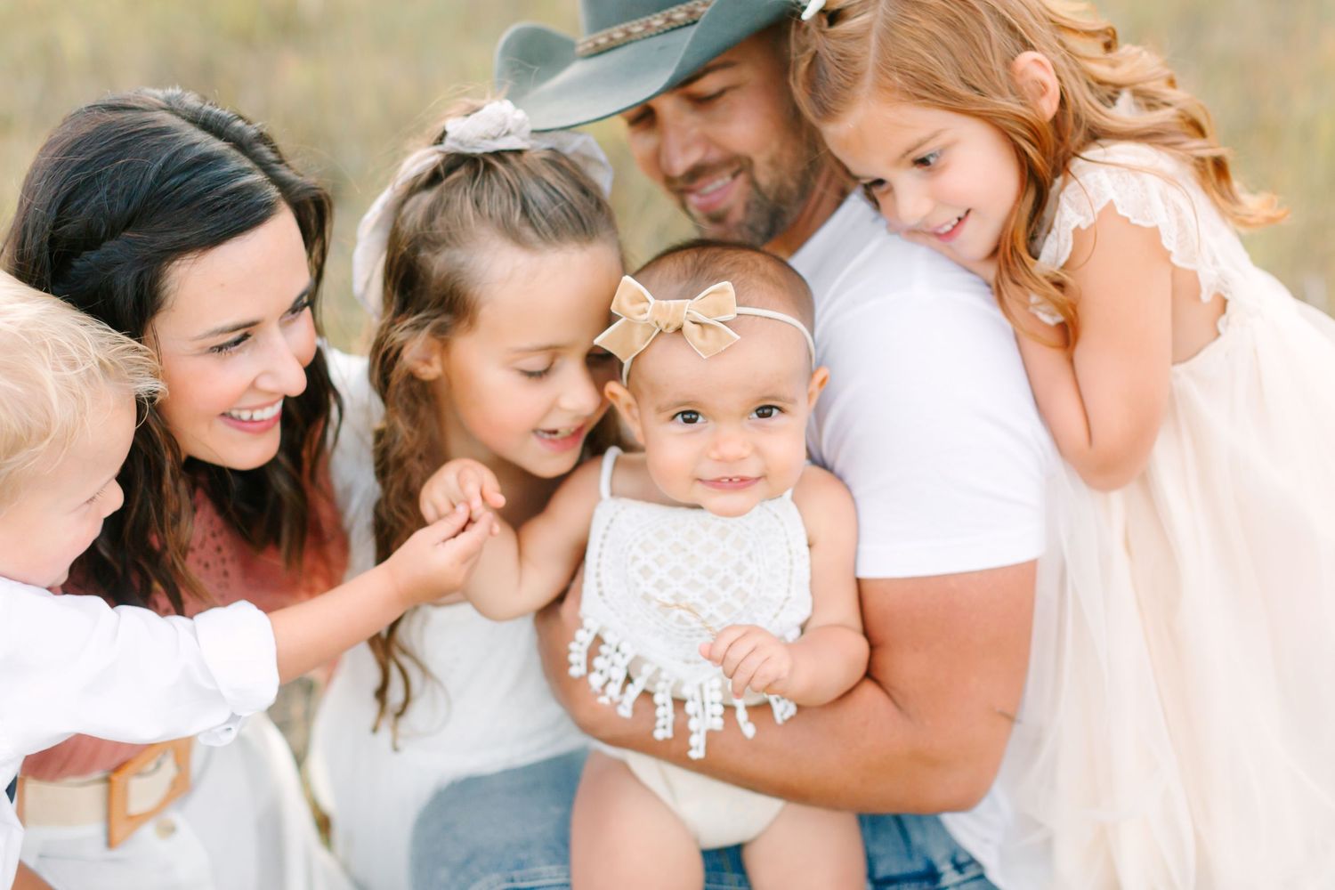 A series of candid family portraits showing tender moments between parents and children in an outdoor setting.