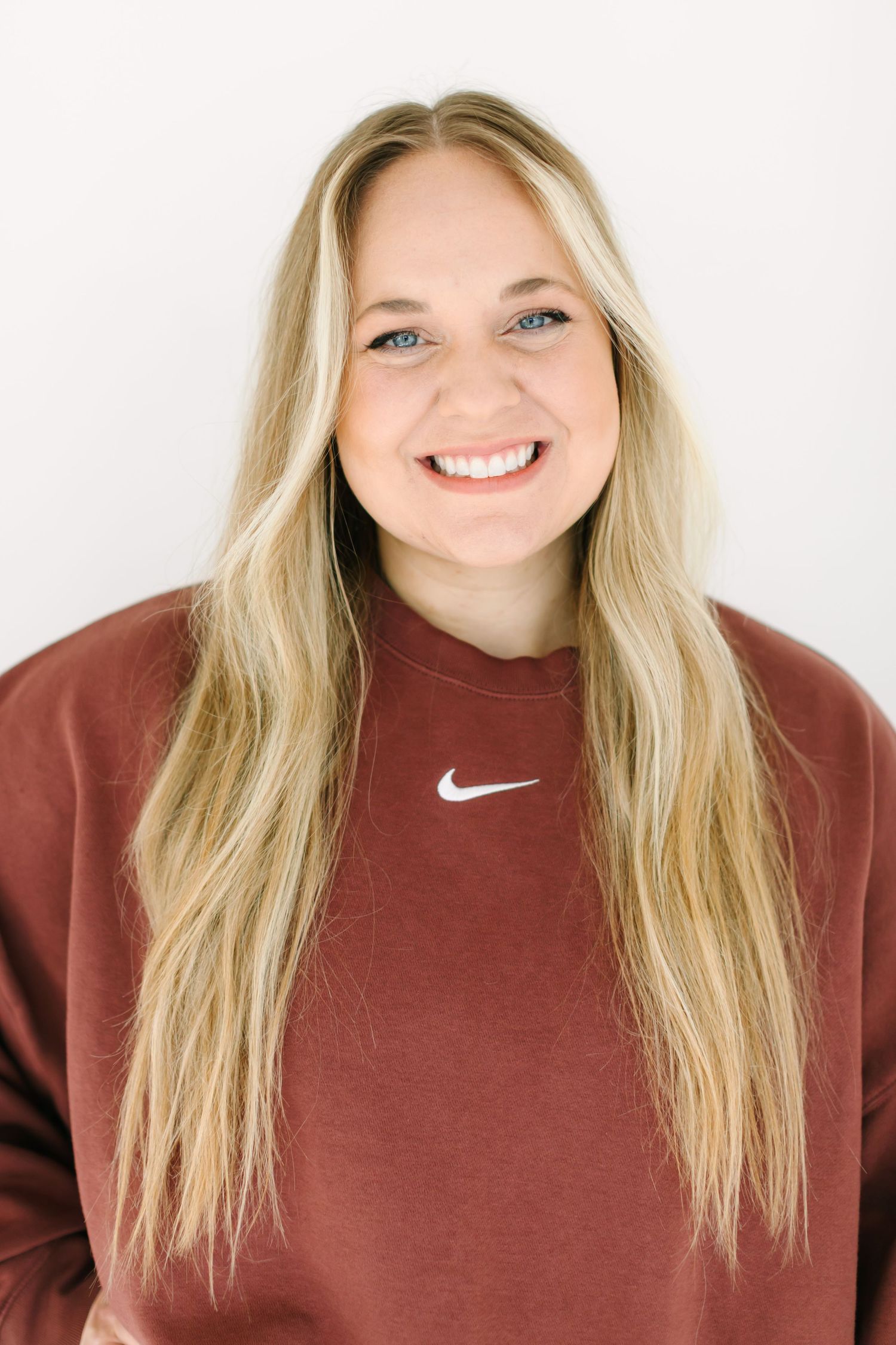 Four headshots showing a person with blonde hair wearing a burgundy Nike sweatshirt against a white background.