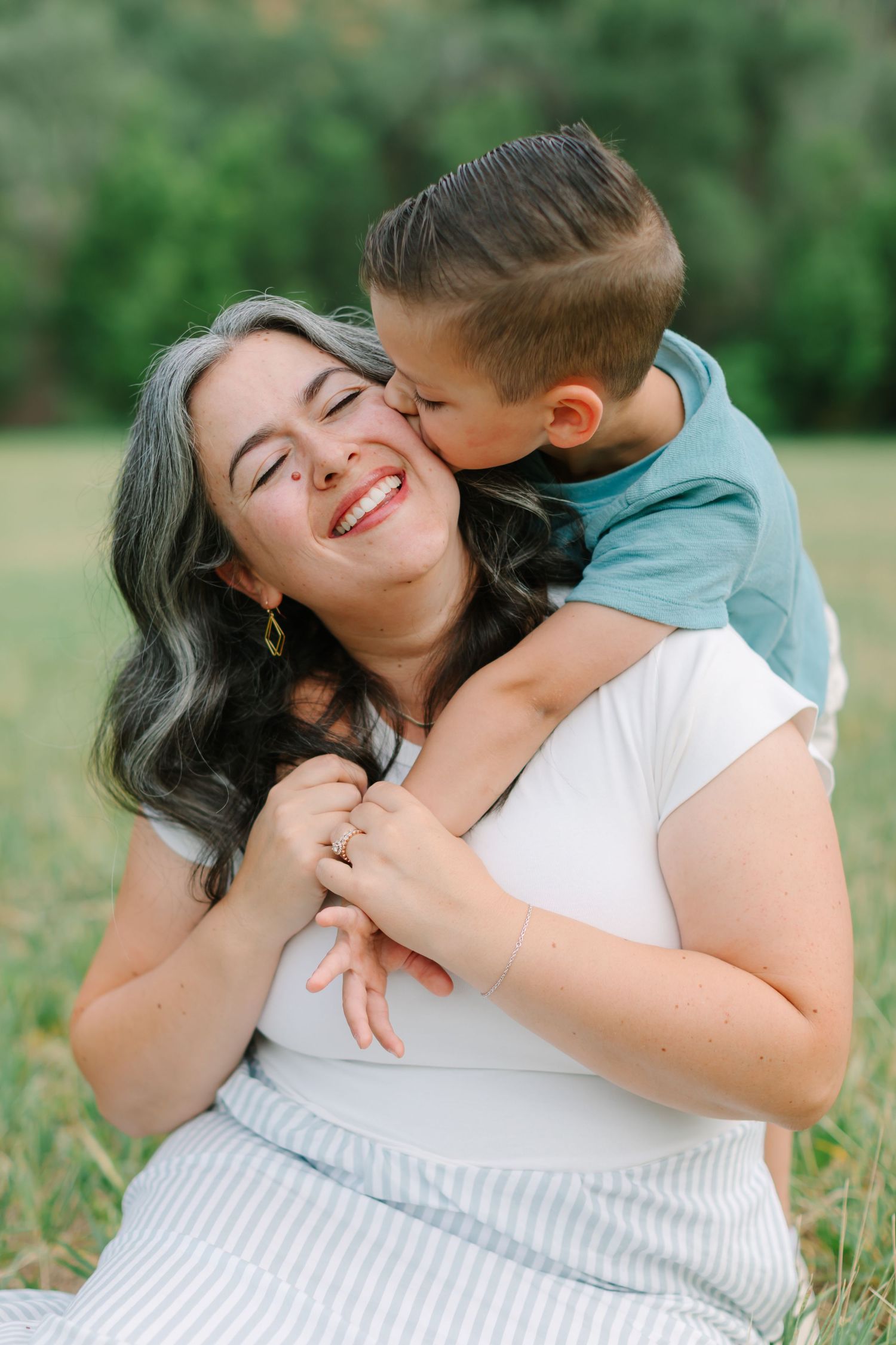 A joyful moment captured in a grassy outdoor setting with natural light and laughter.