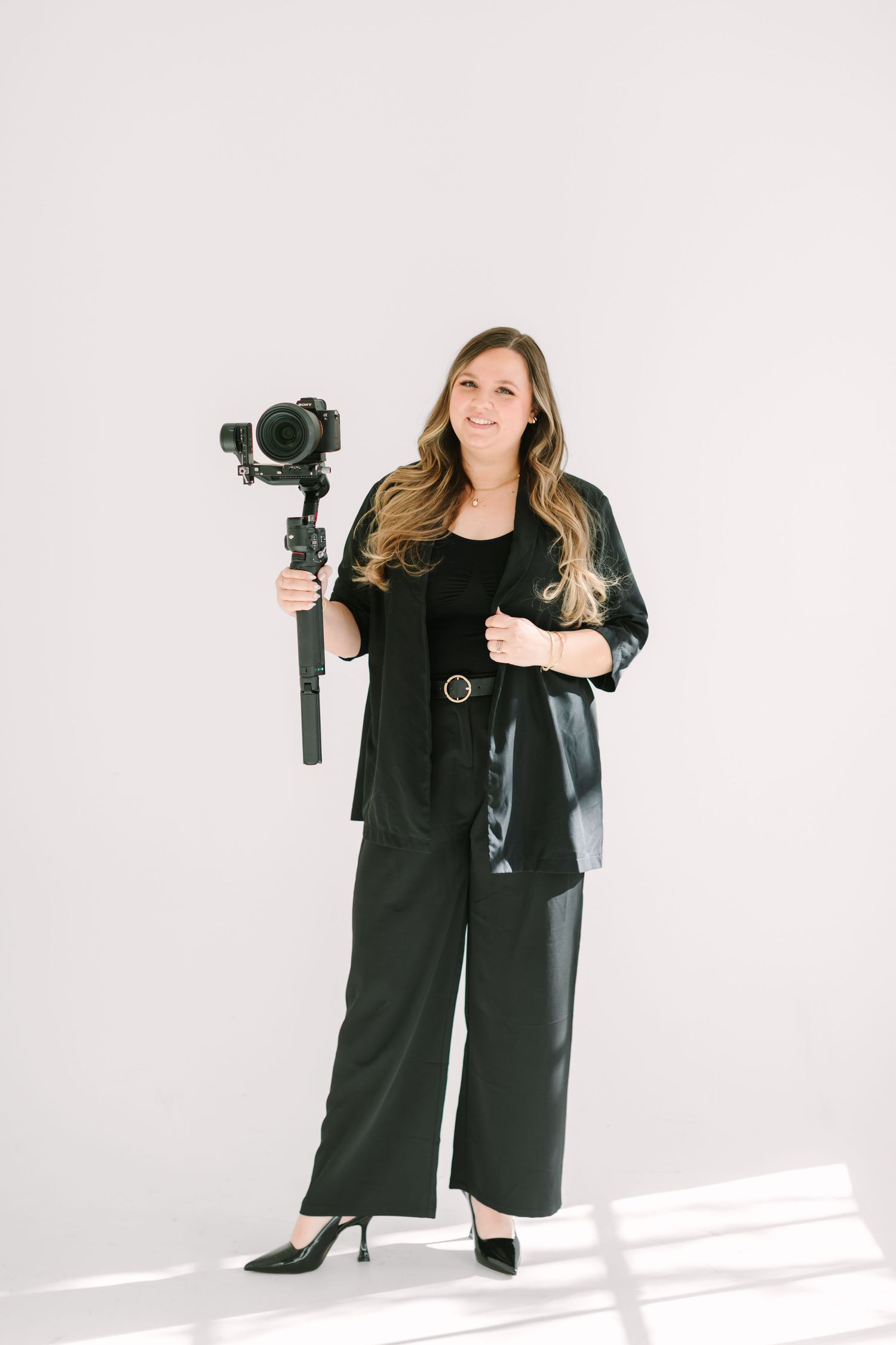 A person wearing a black outfit poses against a white background in four sequential shots.