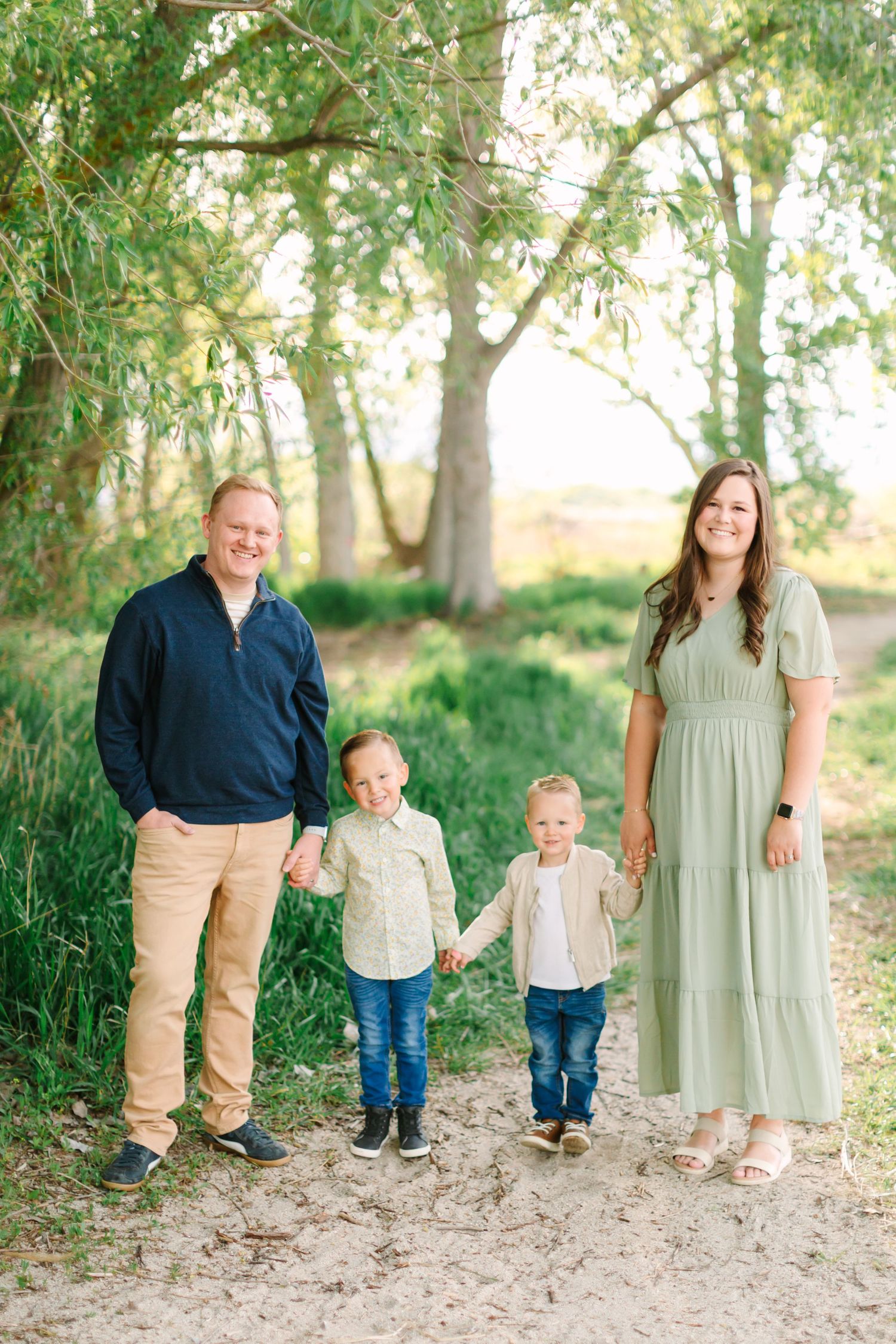 Family portrait series on a dirt path surrounded by green trees and natural scenery.