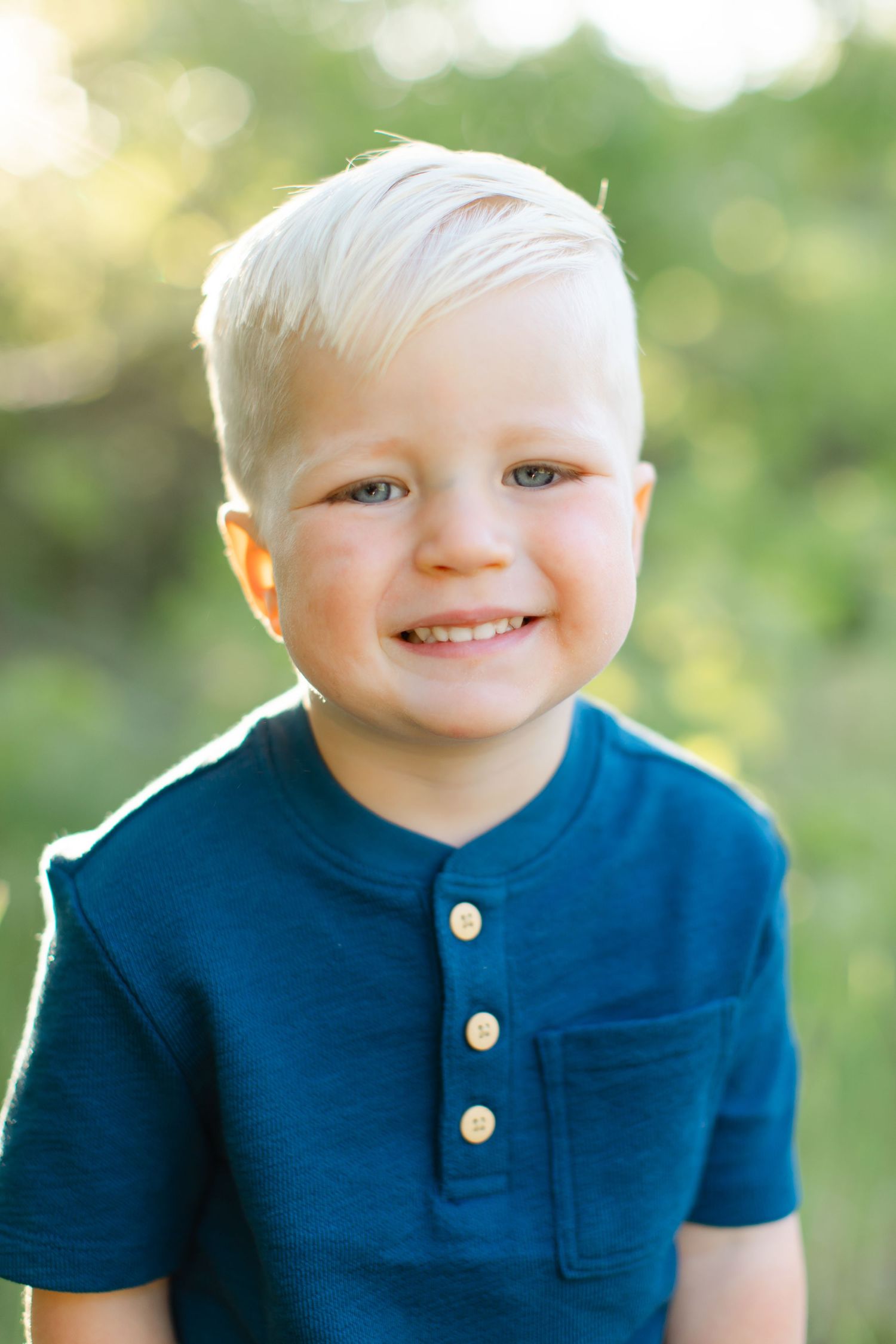 A series of close-up shots showing a young child in a navy blue polo shirt smiling against a blurred green background.