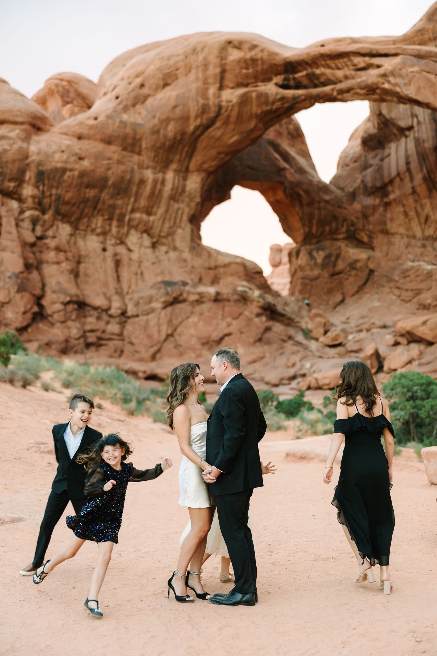 A series of romantic dance poses captured against stunning red rock formations in a desert landscape.