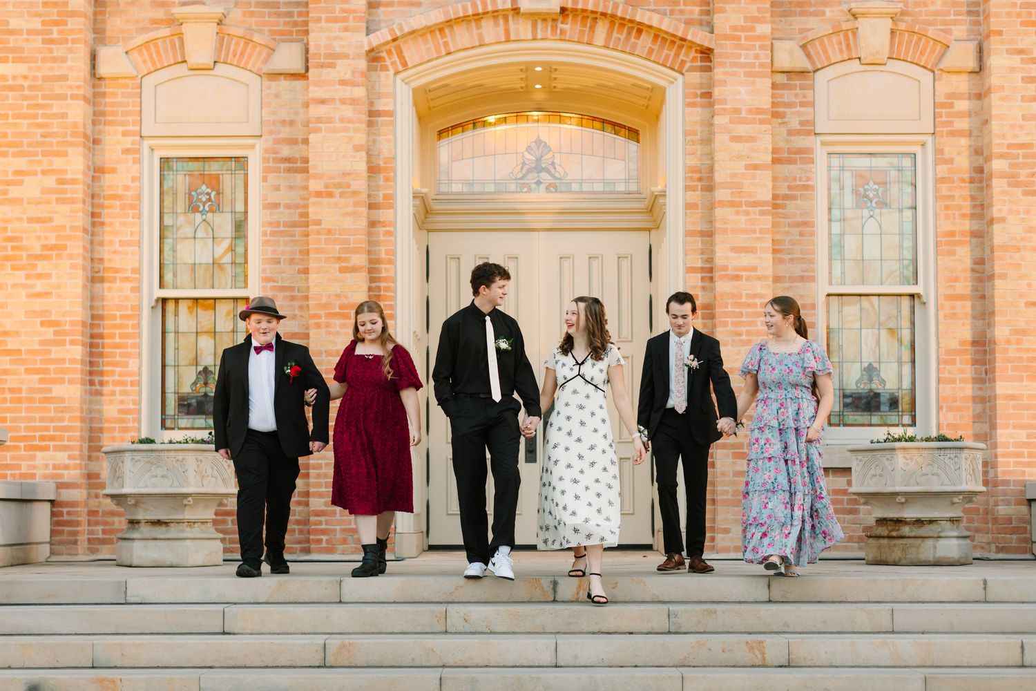 A group of high schoolers walk down the stairs at the Provo City Center temple in Provo, Utah during their high school dance photo session.