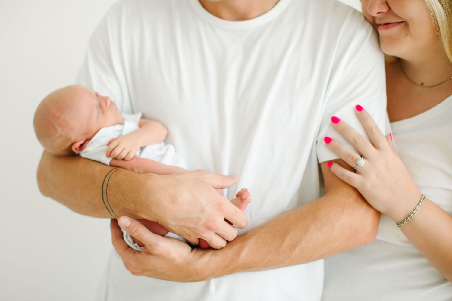 Parents lovingly cradle and admire their newborn baby in a series of tender moments against a white background.