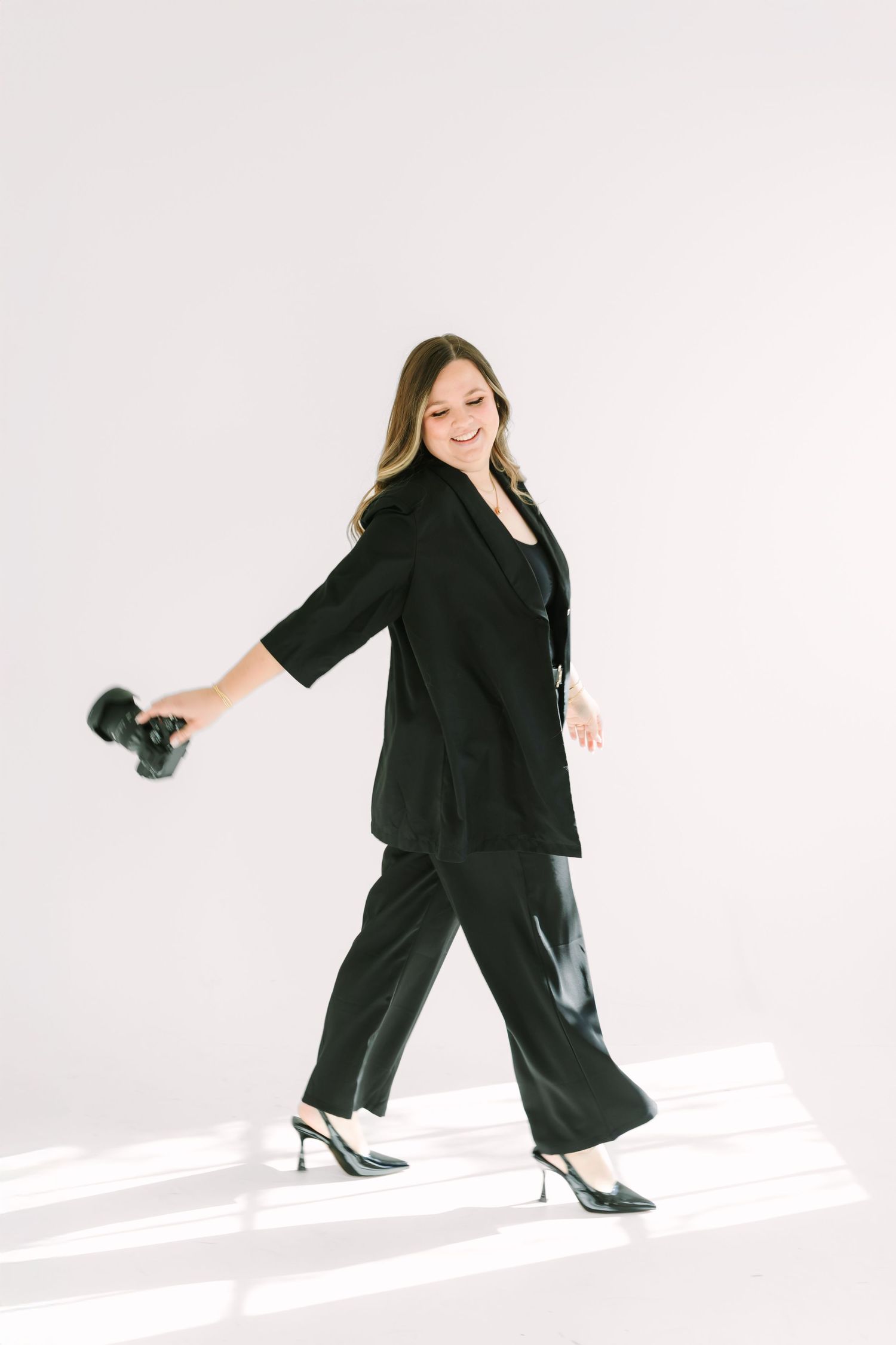 A sequence of three photos showing a person in black clothing making dynamic dance movements against a white background.