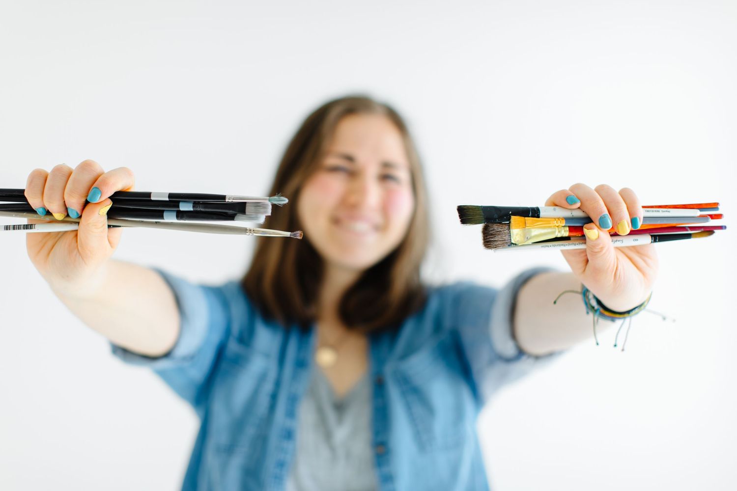 Person holding and displaying various markers against white background at White Space Studios in Provo, Utah in Utah County..