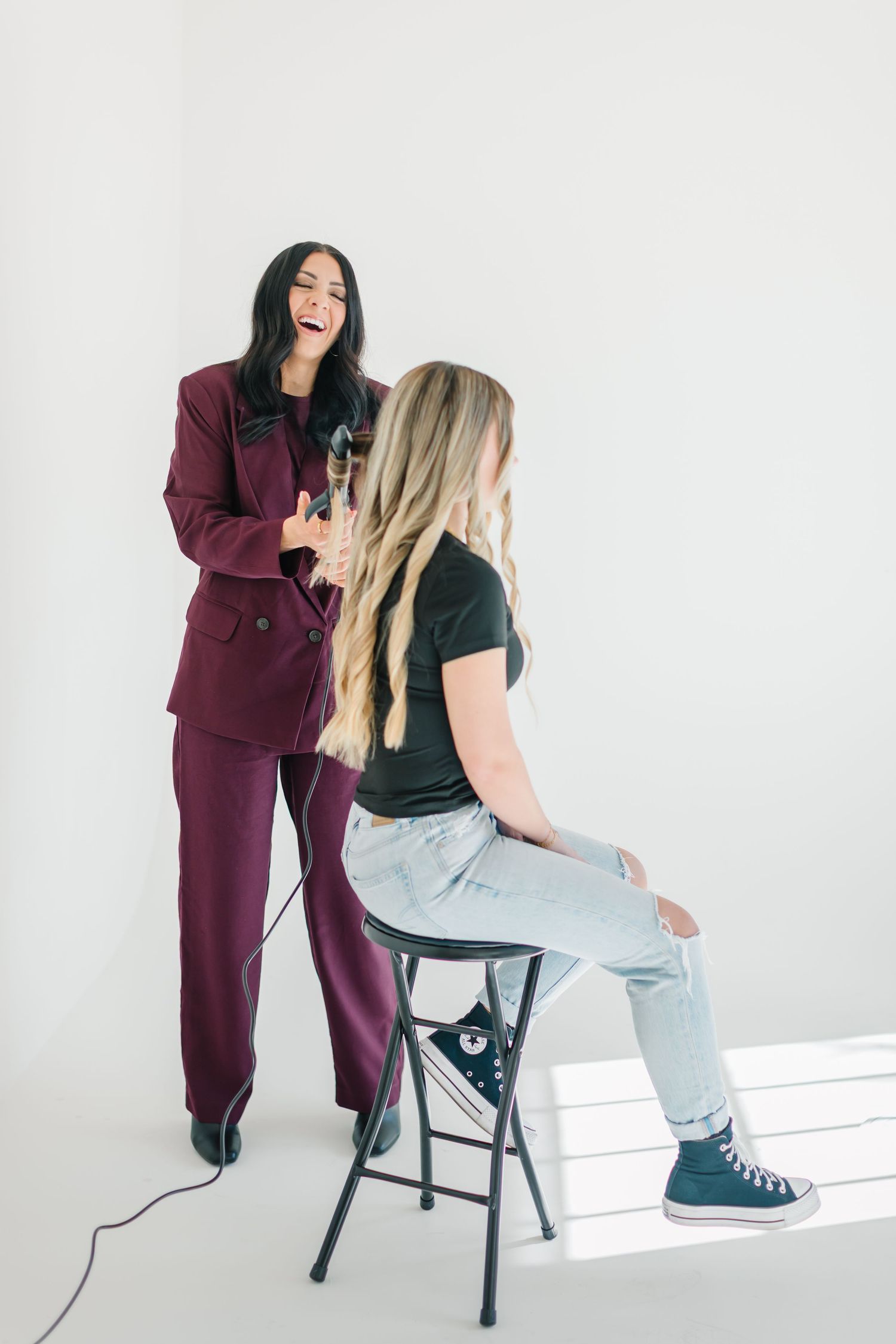 Hair styling demonstration showing professional working with client in casual setting at White Space Studios in Provo, Utah in Utah County..