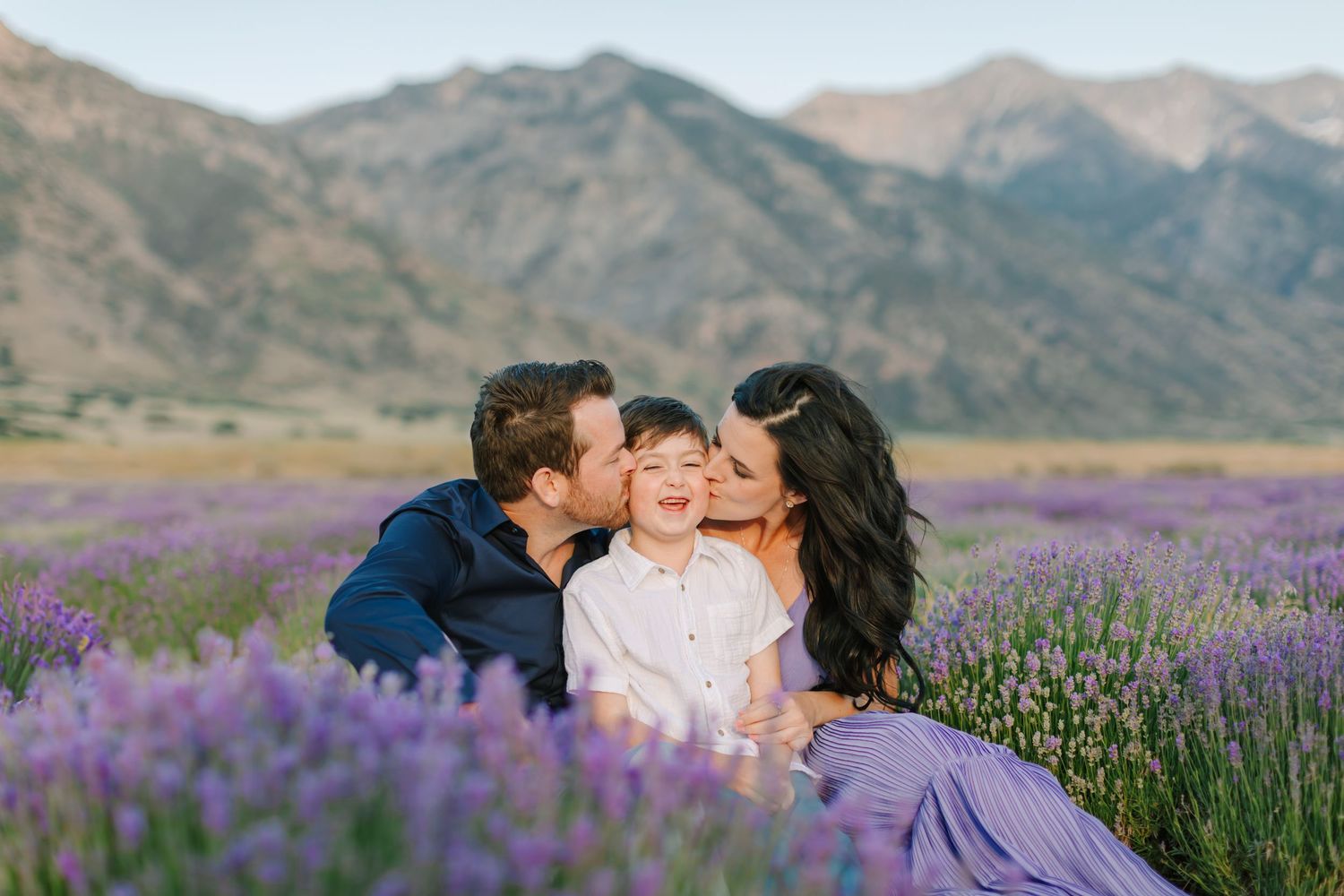 A family shares a tender moment together during their family photoshoot in the lavender at Young Living Lavender Field in Mona, Utah.