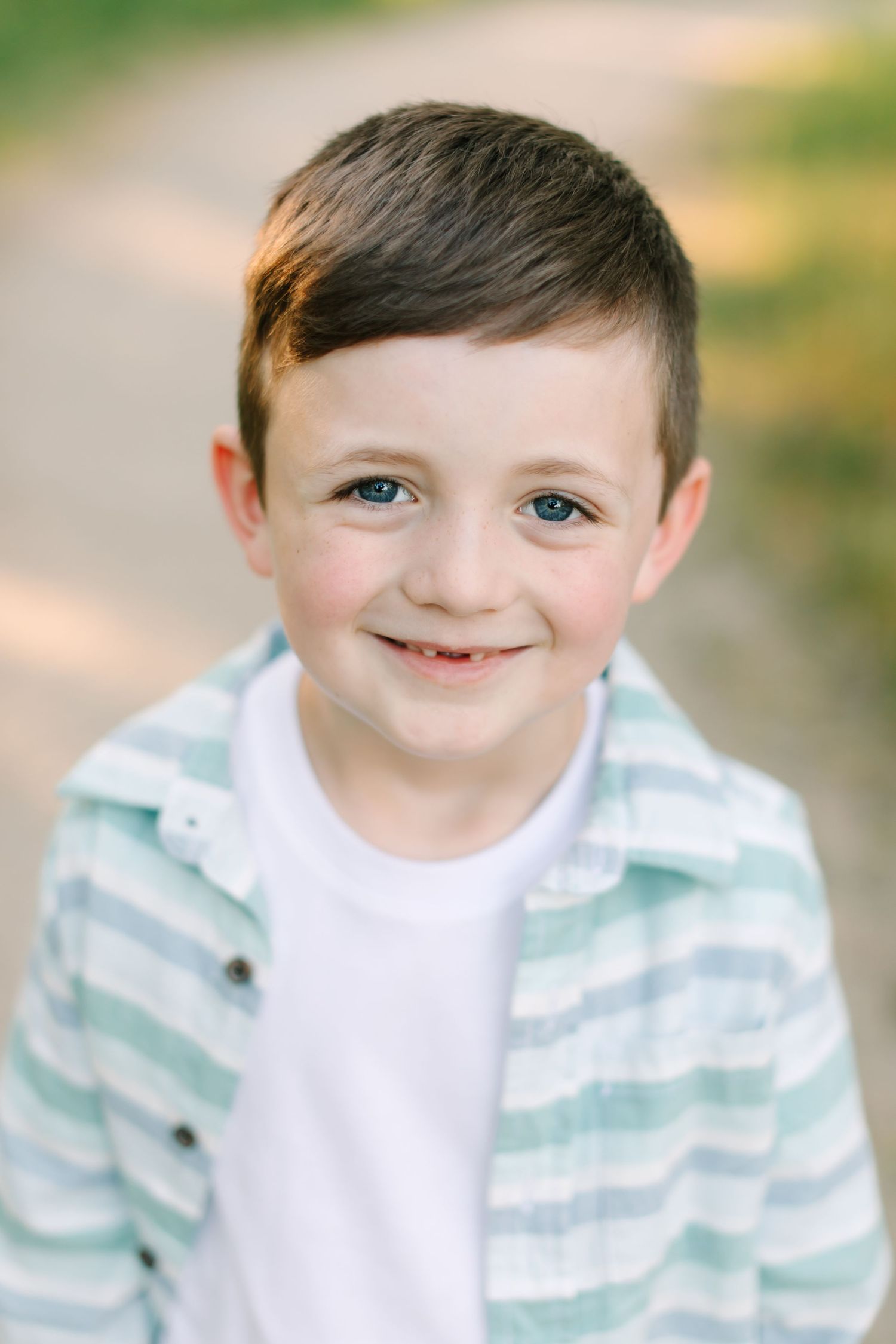 A series of five close-up portraits showing a child wearing a mint striped sweater against a soft blurred background.