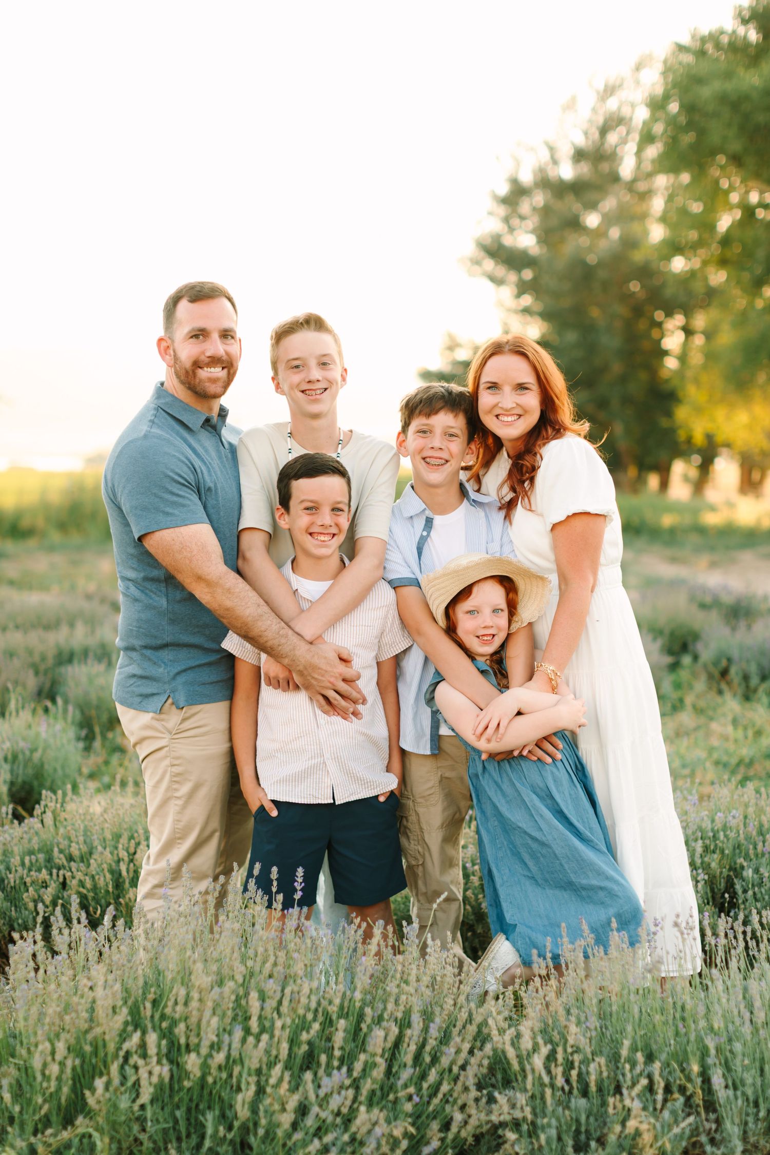 A family shares joyful moments together in a blooming lavender field at sunset.