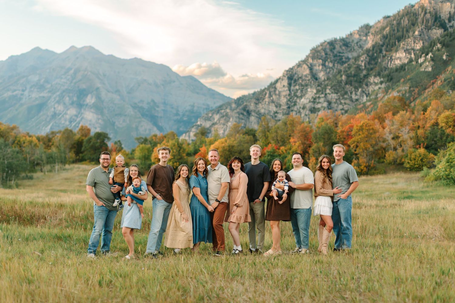 An extended family is smiling for their family photoshoot in a beautiful fall mountain scene at Buffalo Peak in Provo, Utah.