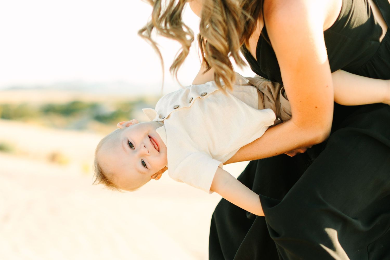 A couple embraces and dances together in a romantic outdoor setting with golden sunlight filtering through.