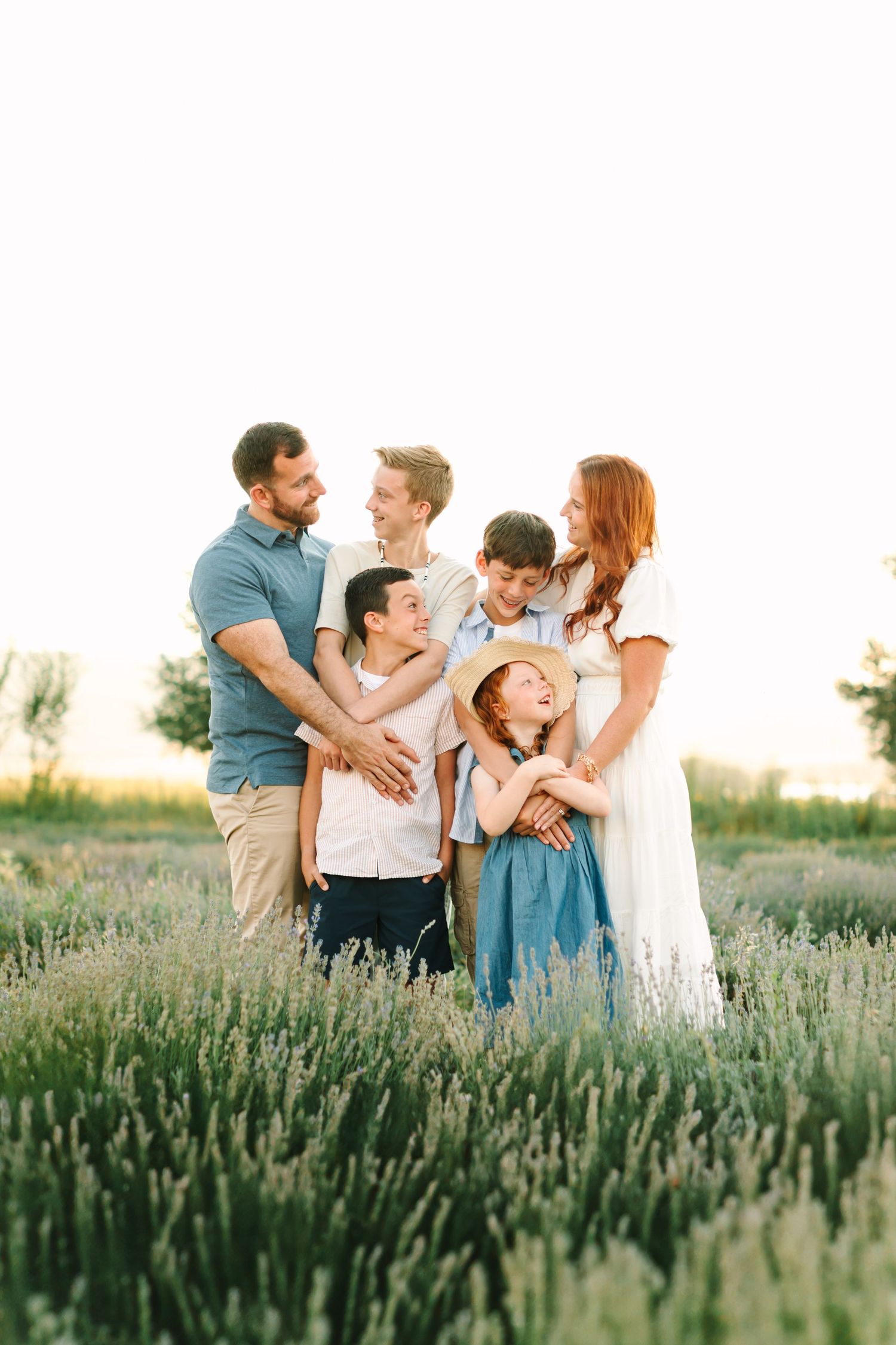 A family shares joyful moments together in a blooming lavender field during golden hour.