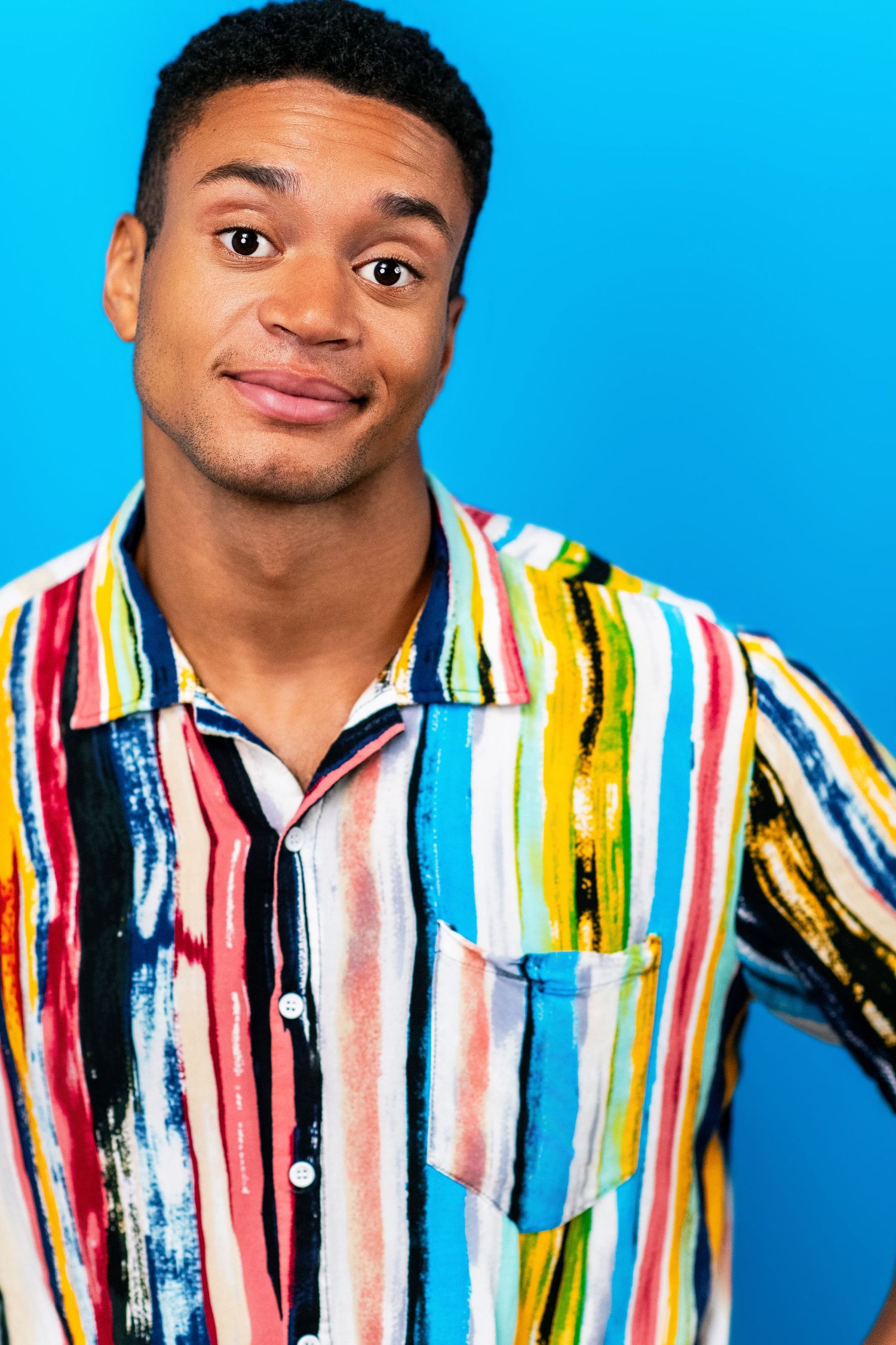 Expressive actor headshot of a young man against a blue backdrop in a Los Angeles headshot studio