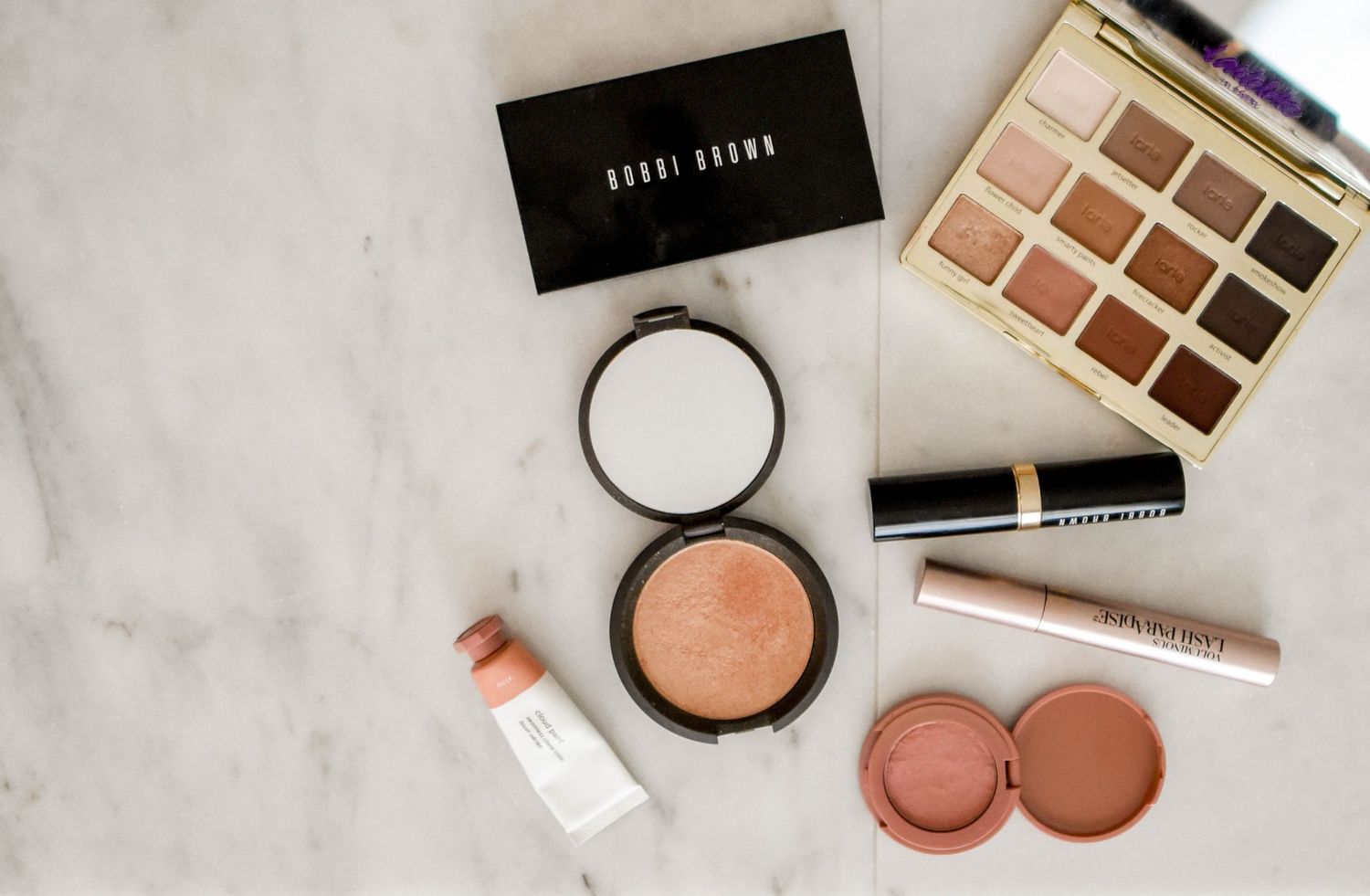 Makeup products laid out on a counter, representing natural, camera-ready makeup preparation for headshots