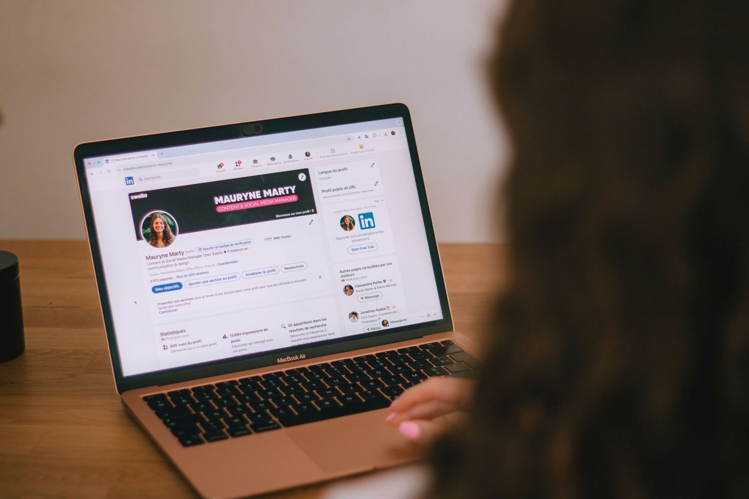 Person reviewing LinkedIn profile on MacBook Air with focus on profile photo section