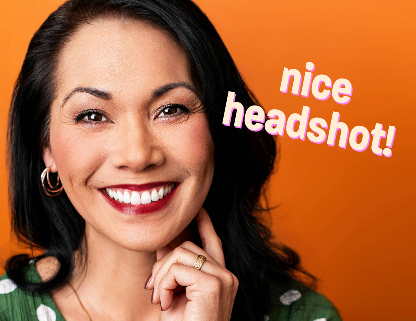 Professional headshot of a smiling woman with a vibrant orange backdrop, captured in a Los Angeles headshot photography session.
