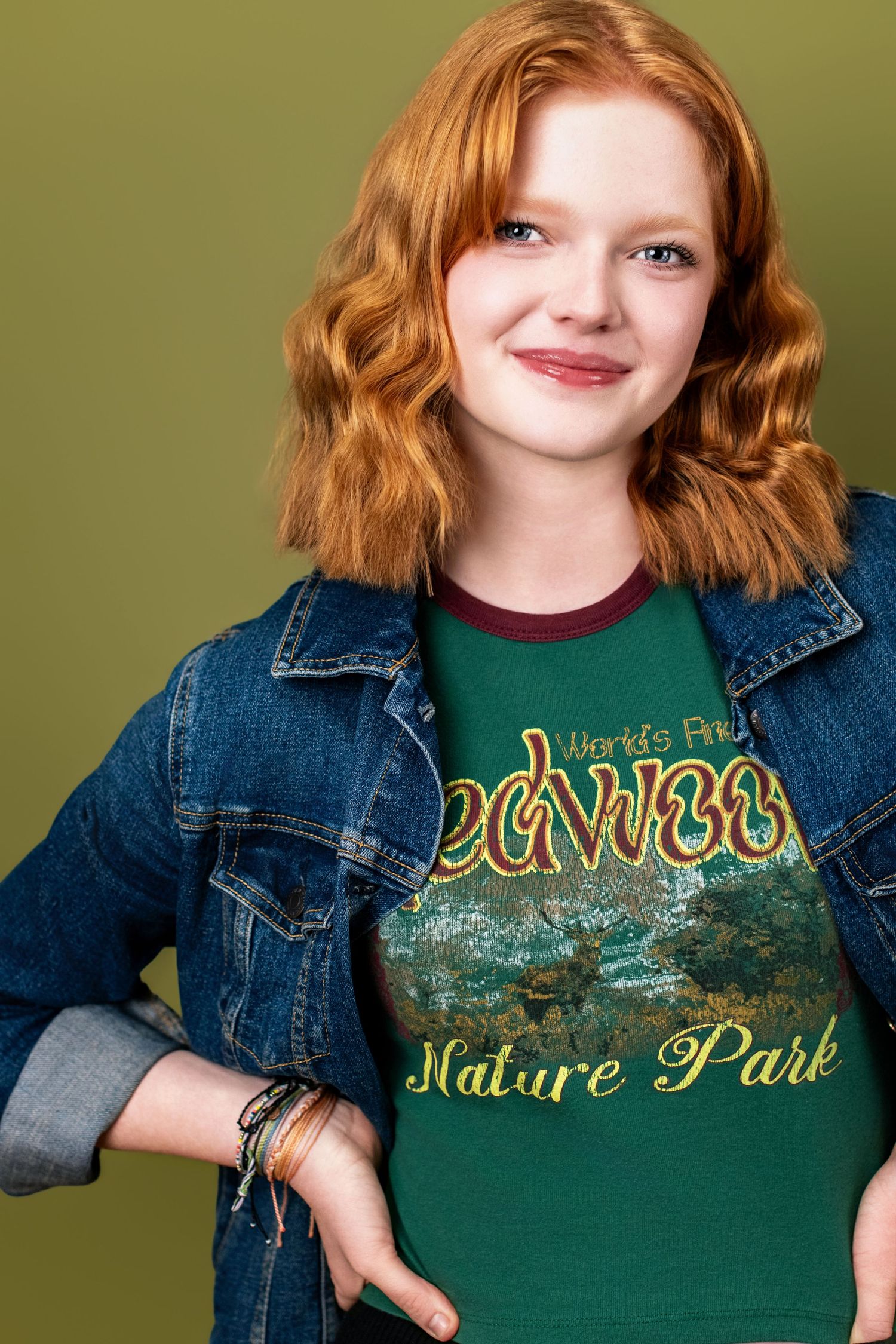 Teen actor theatrical headshot with natural expression and casual styling on a green background, suited for film and television casting