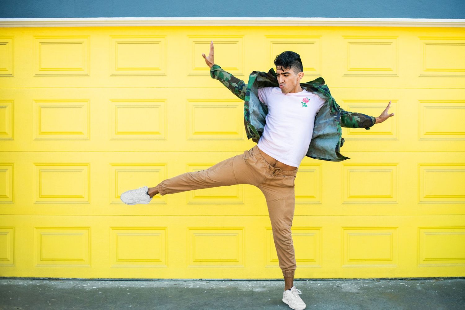 Lifestyle headshot featuring a man in motion against a bold yellow background, photographed in Los Angeles