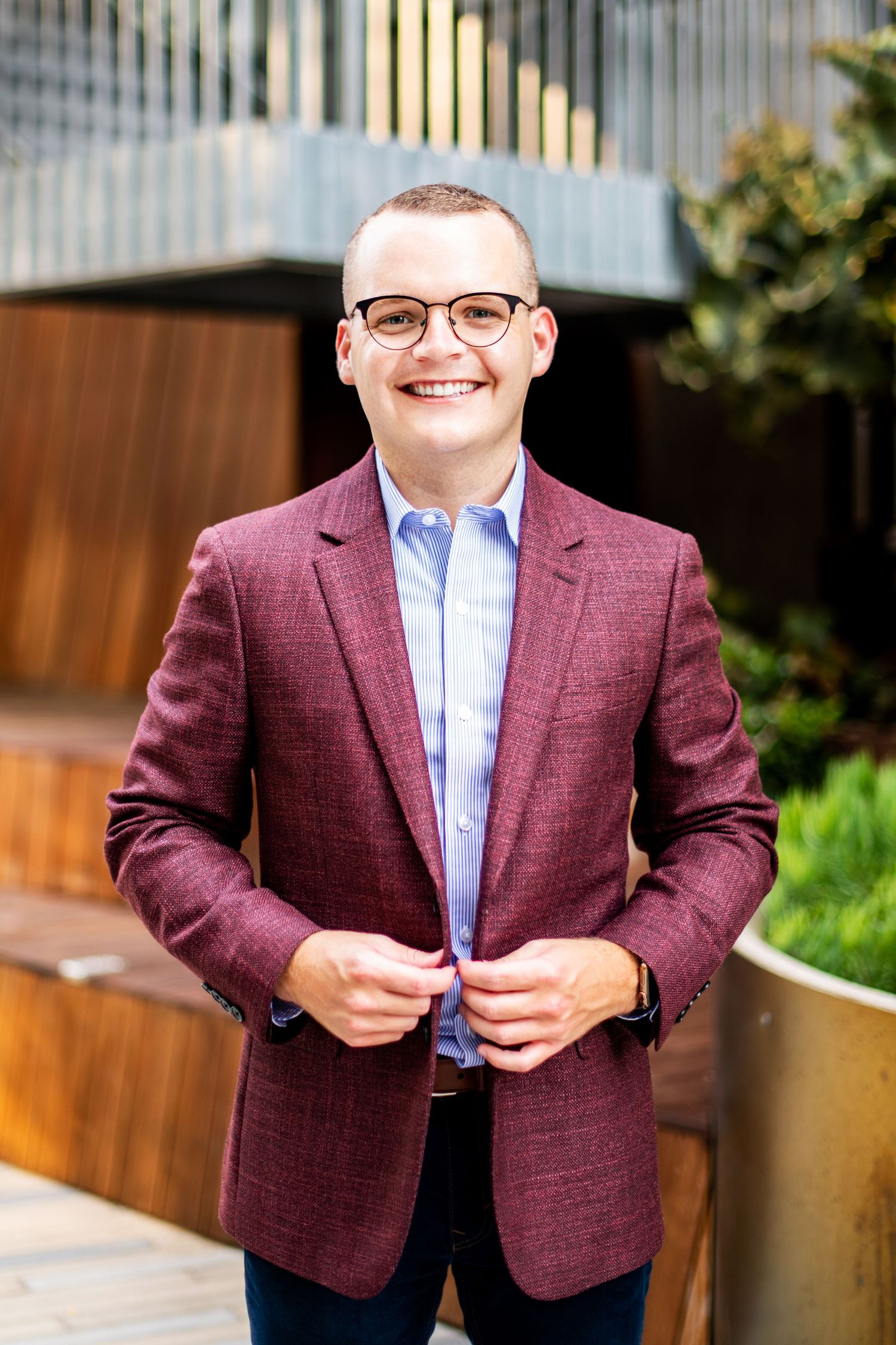 Male business professional wearing a burgundy blazer, photographed outdoors in a modern setting for a professional headshot in Los Angeles.