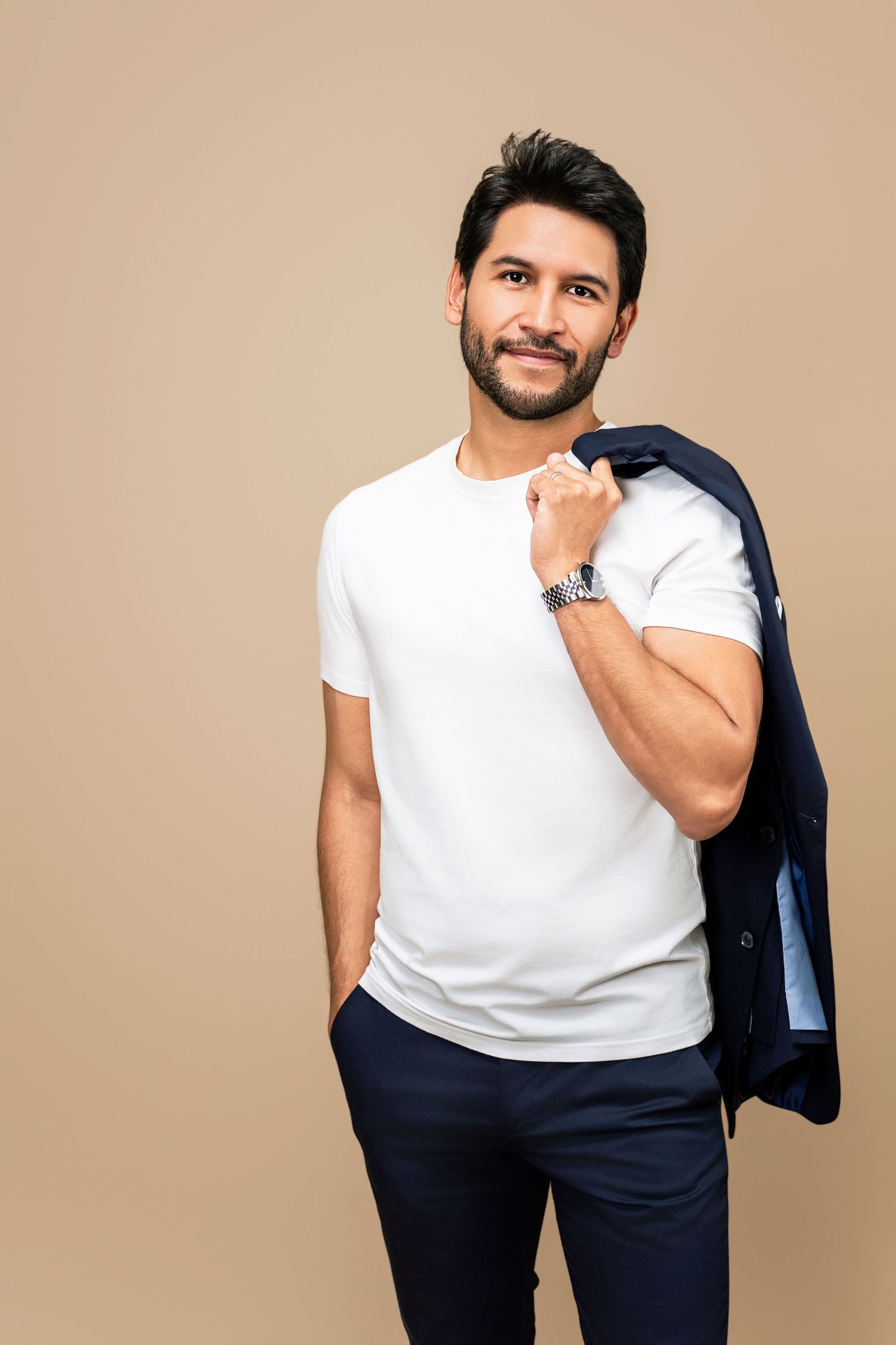 Male model in a white t-shirt with a blazer over his shoulder, photographed for a professional modeling headshot in Los Angeles.
