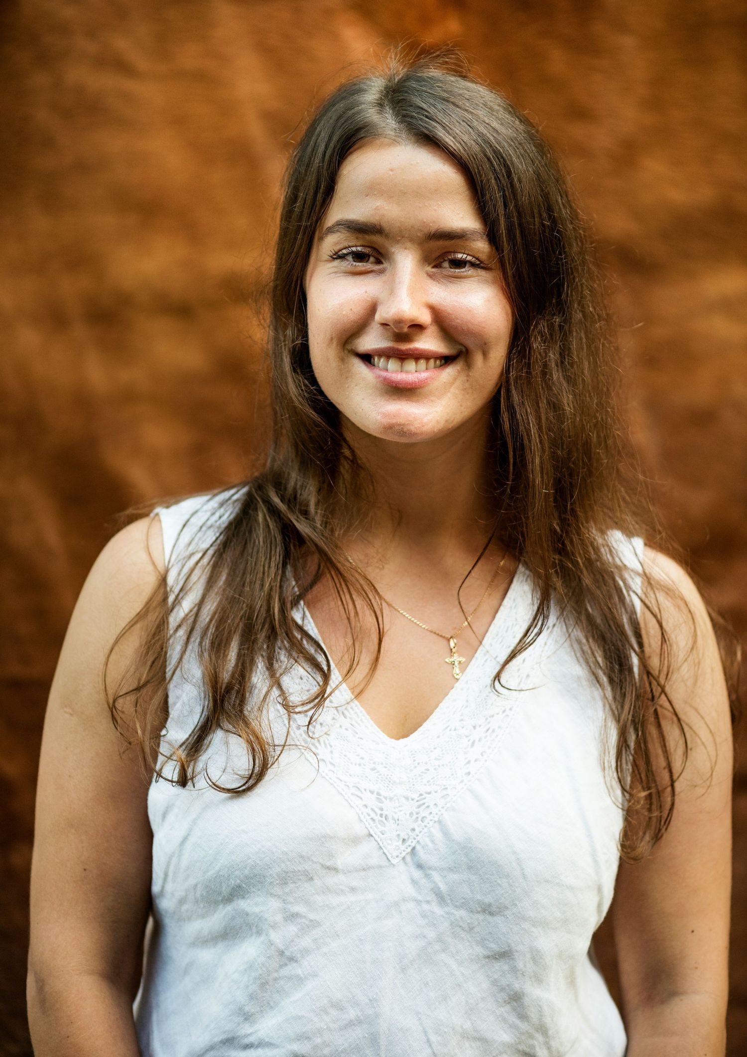 Natural headshot with little to no retouching, showing visible skin texture, flyaway hairs and clothing wrinkles.