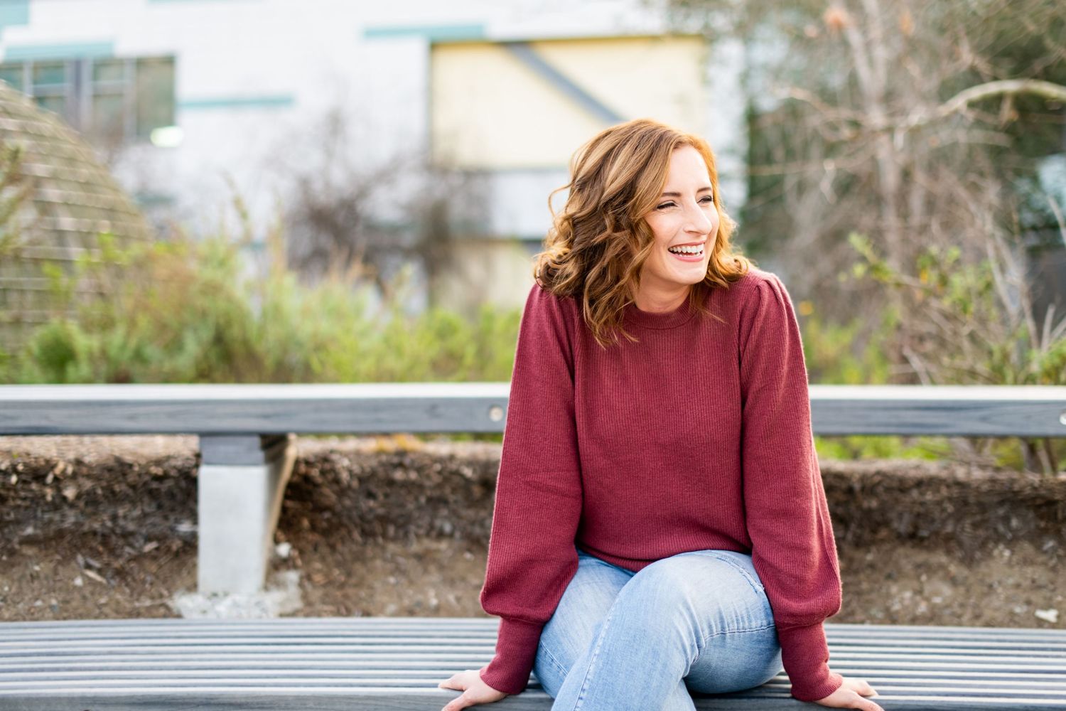 Candid lifestyle headshot of woman laughing outdoors in Los Angeles, relaxed natural expression with soft background.
