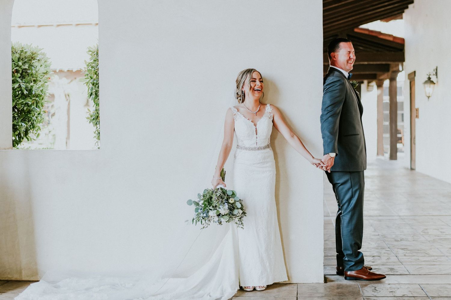 Bride and groom share a joyful first touch before their wedding ceremony, capturing a genuine and emotional wedding moment.