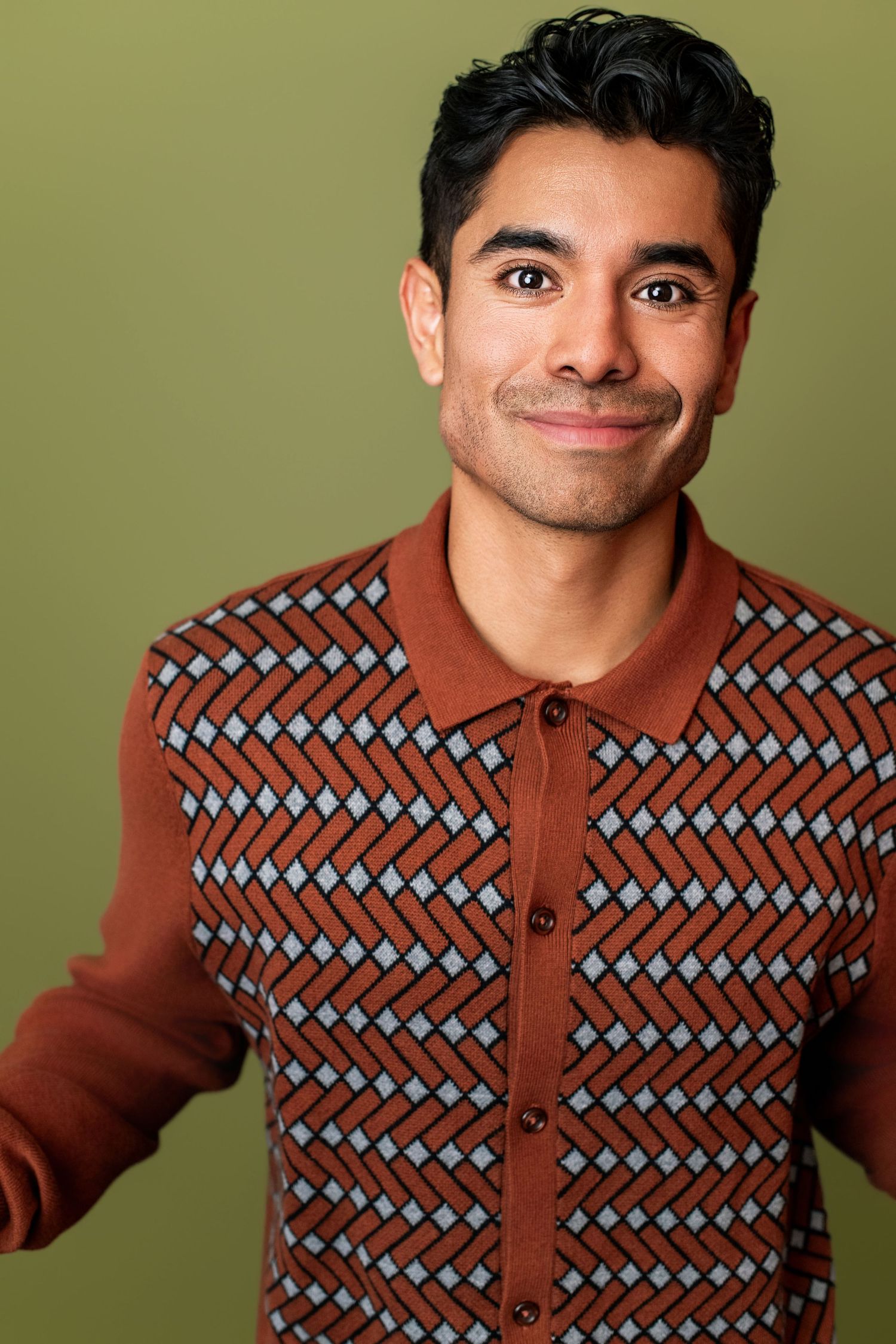 Commercial actor headshot featuring a friendly young adult on an olive green background in Los Angeles.